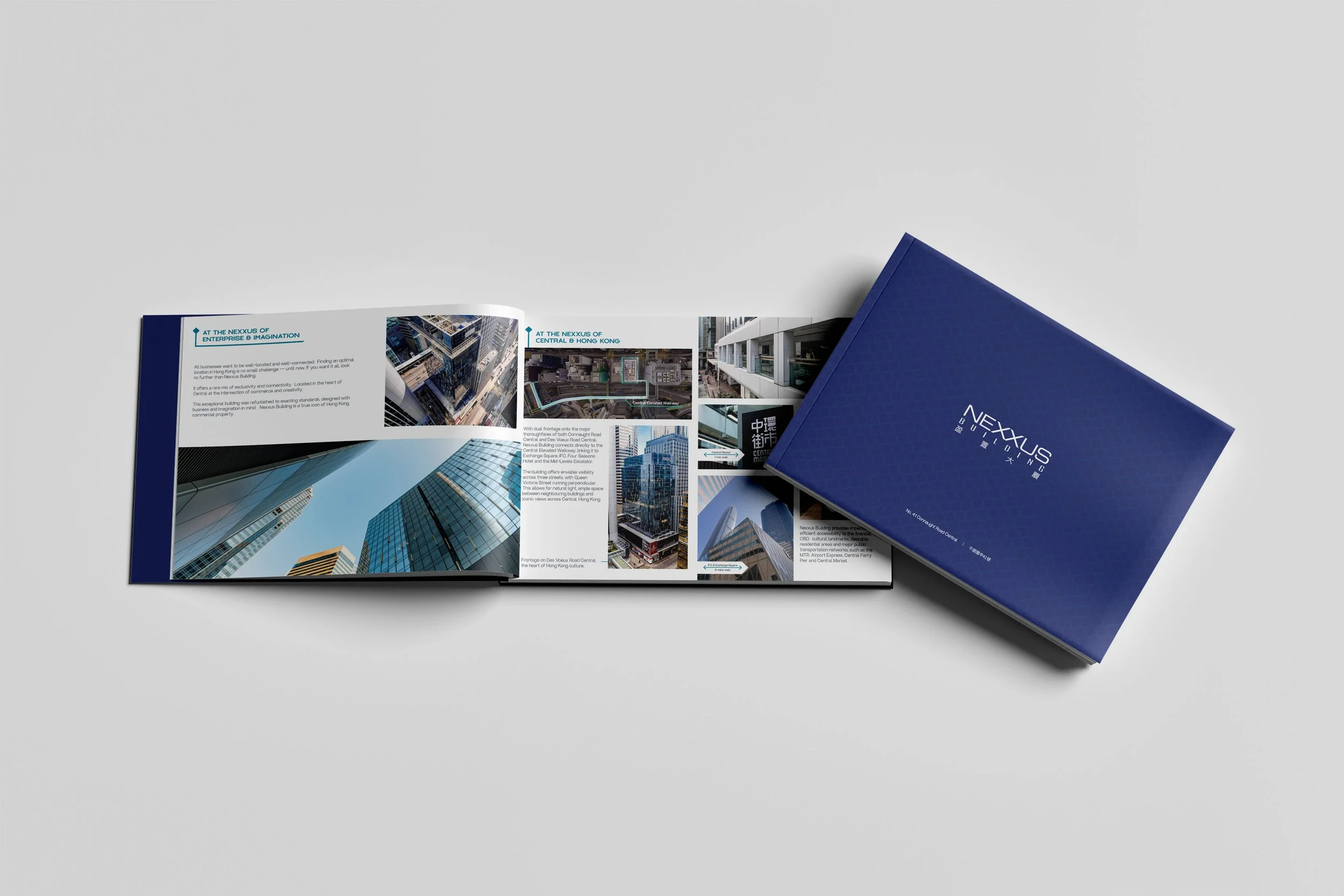 An open brochure displaying images of skyscrapers, streets, and buildings in Hong Kong, with text describing the Nexus building and its features, placed on a plain gray surface.