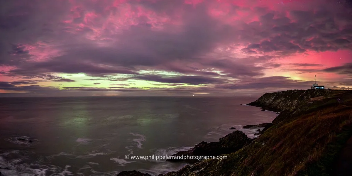 Aurore boréale à la pointe du Grouin. Le ciel est rose, vert sur le sémaphore et la côte d'émeraude