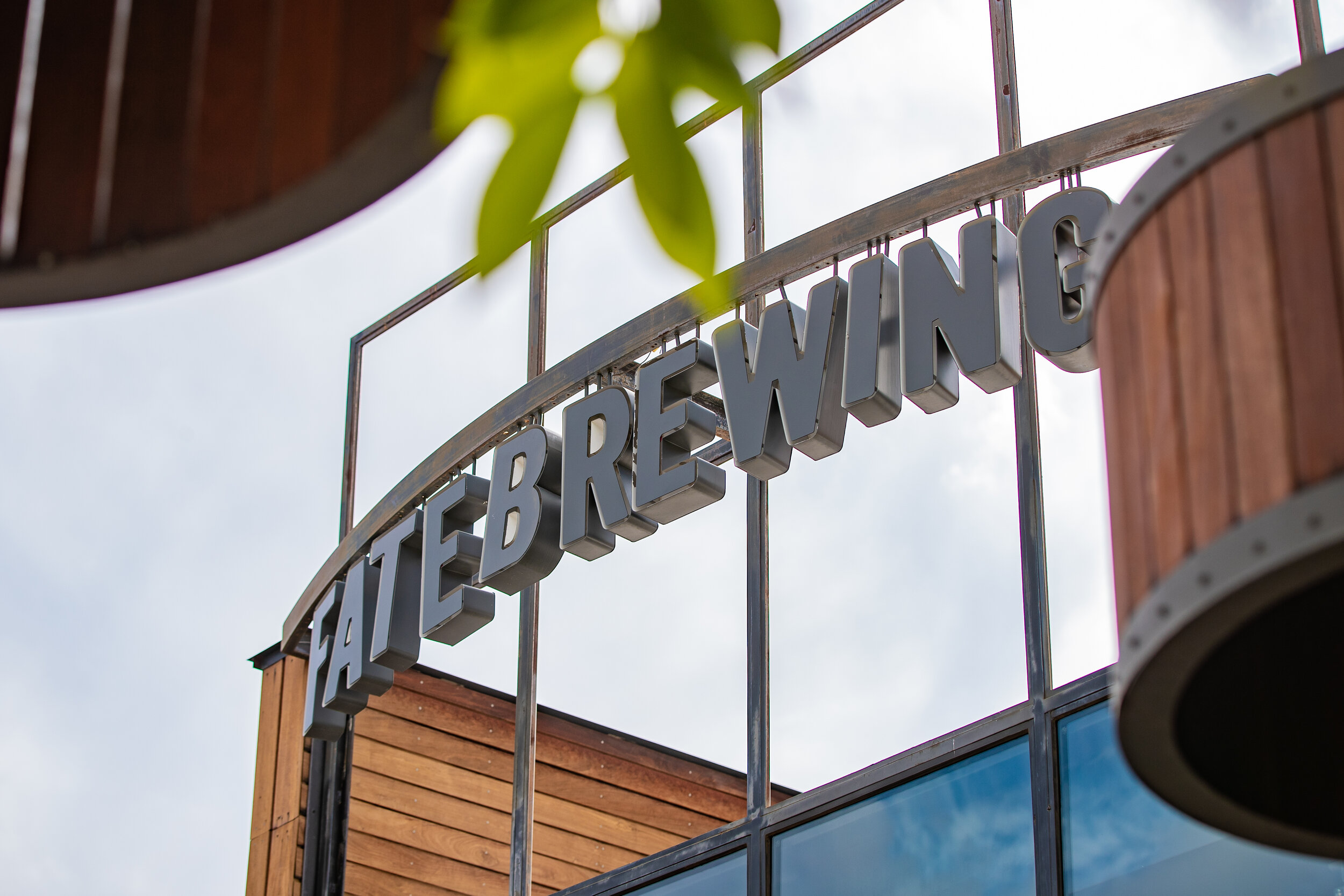 Sign reading 'Tatebreewing' mounted on a building with wooden and glass exterior