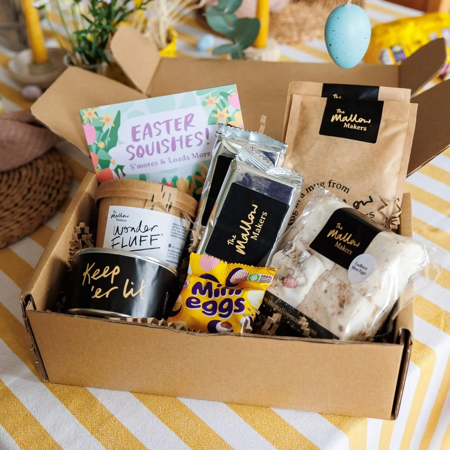 The+Mallow+Makers+Easter+Kit+contents+in+an+opened+gift+box+on+top+of+a+striped+yellow+table+cloth+ona+table+with+easter+decorations.jpg