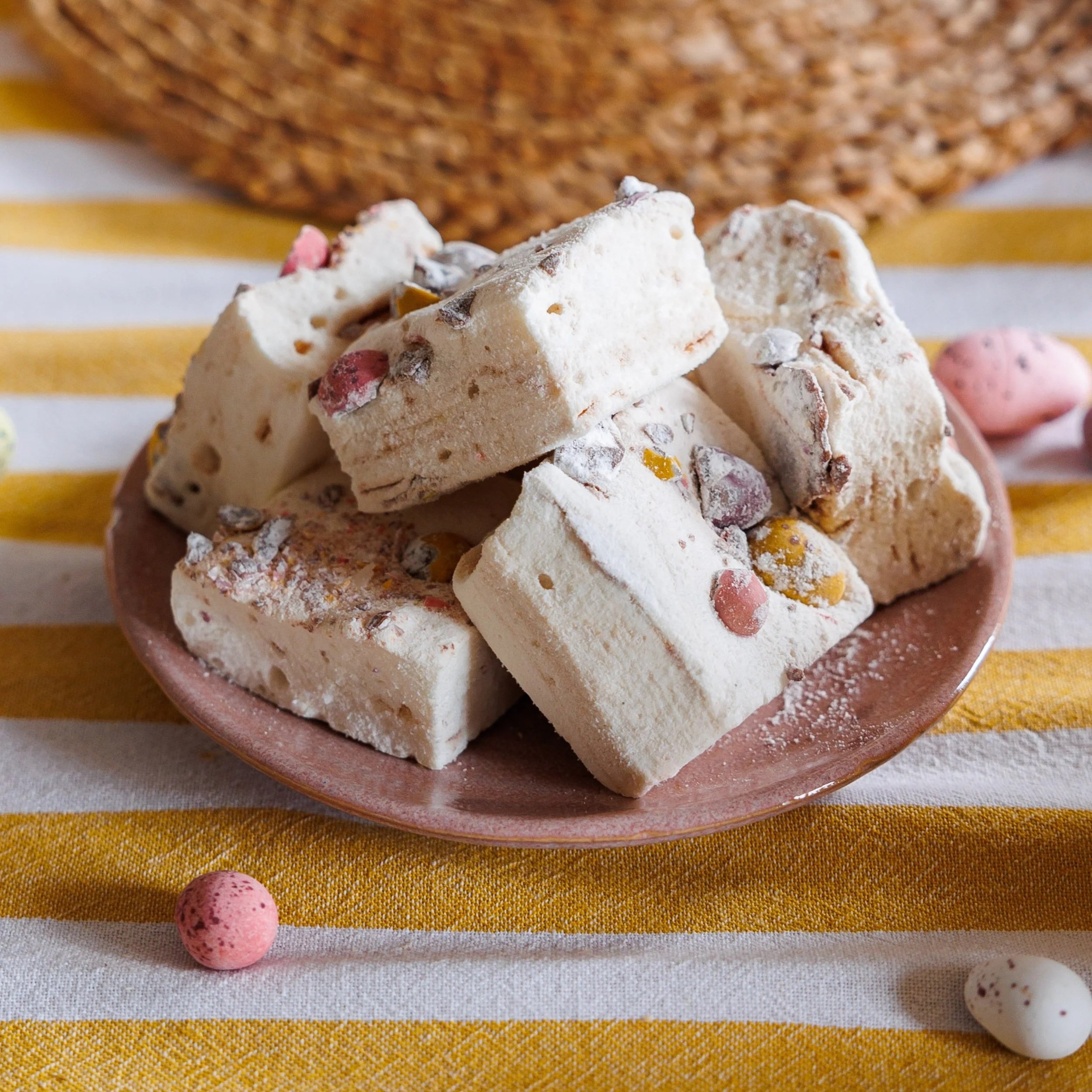Mini+Eggs+marshmallows+piled+on+top+of+a+pink+plate+on+a+striped+yellow+tablecloth.jpg