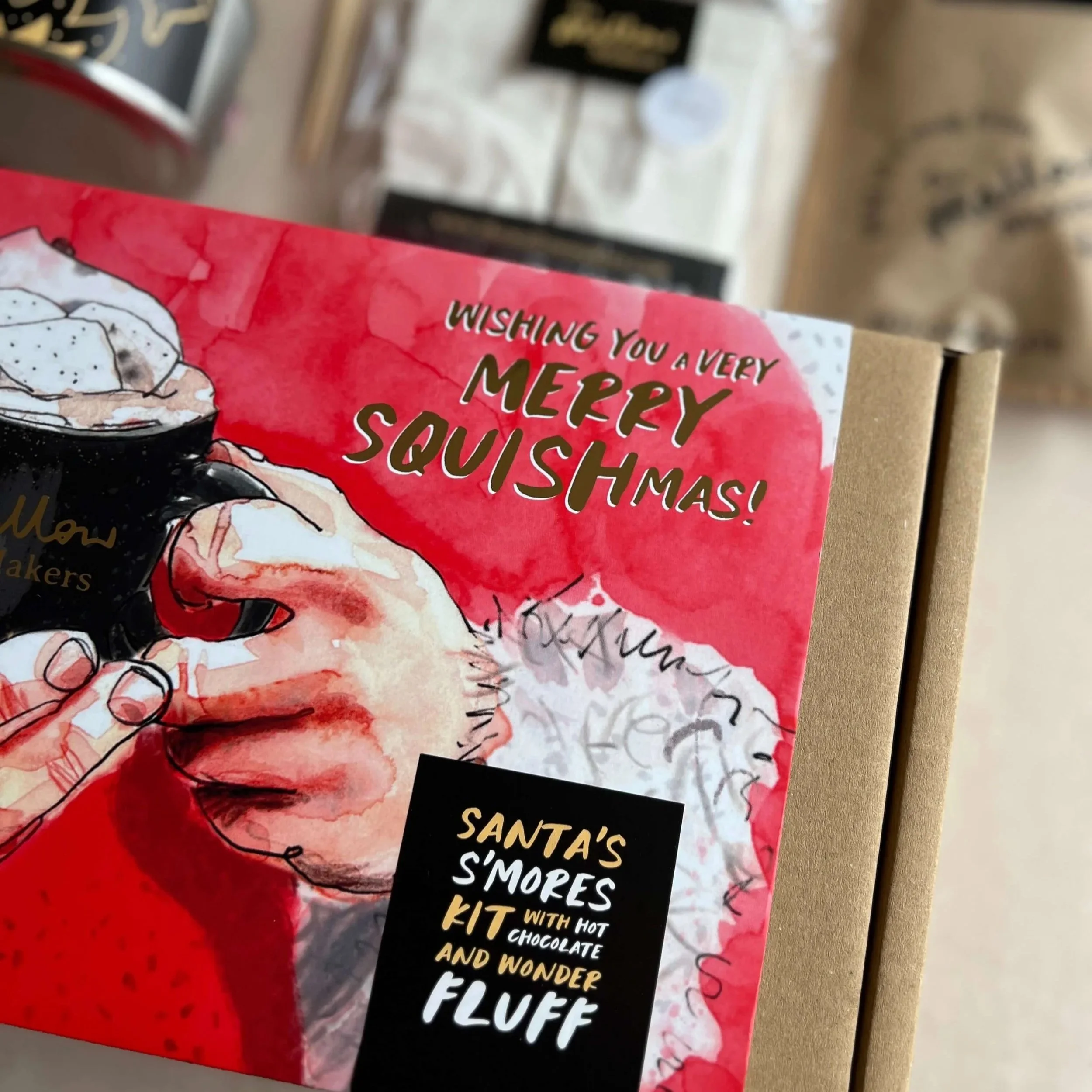 close-up-of-santas-smores-kit-gift-box-with-contents-out-of-focus-behind