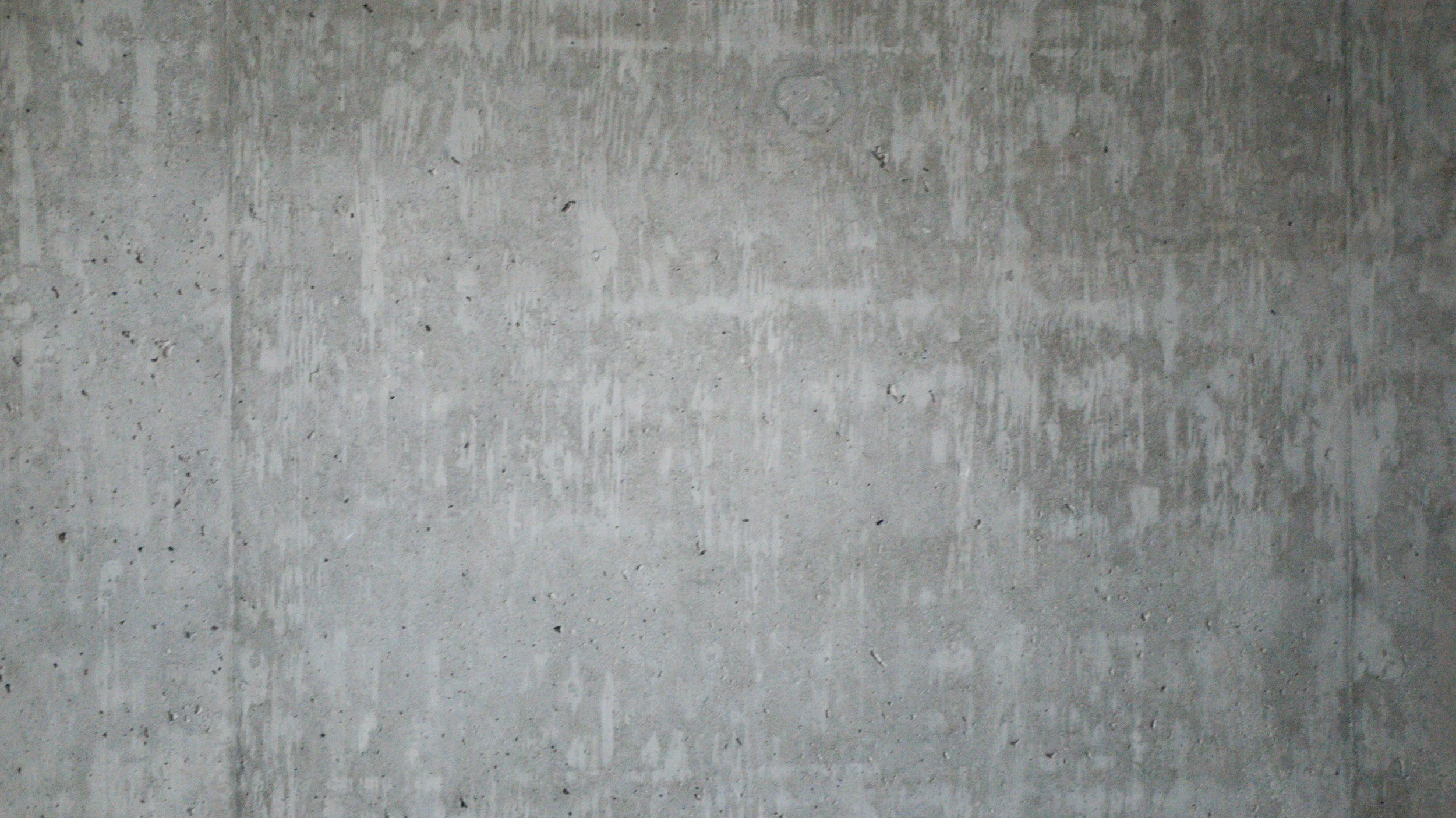 Blank concrete wall with visible texture and small holes.