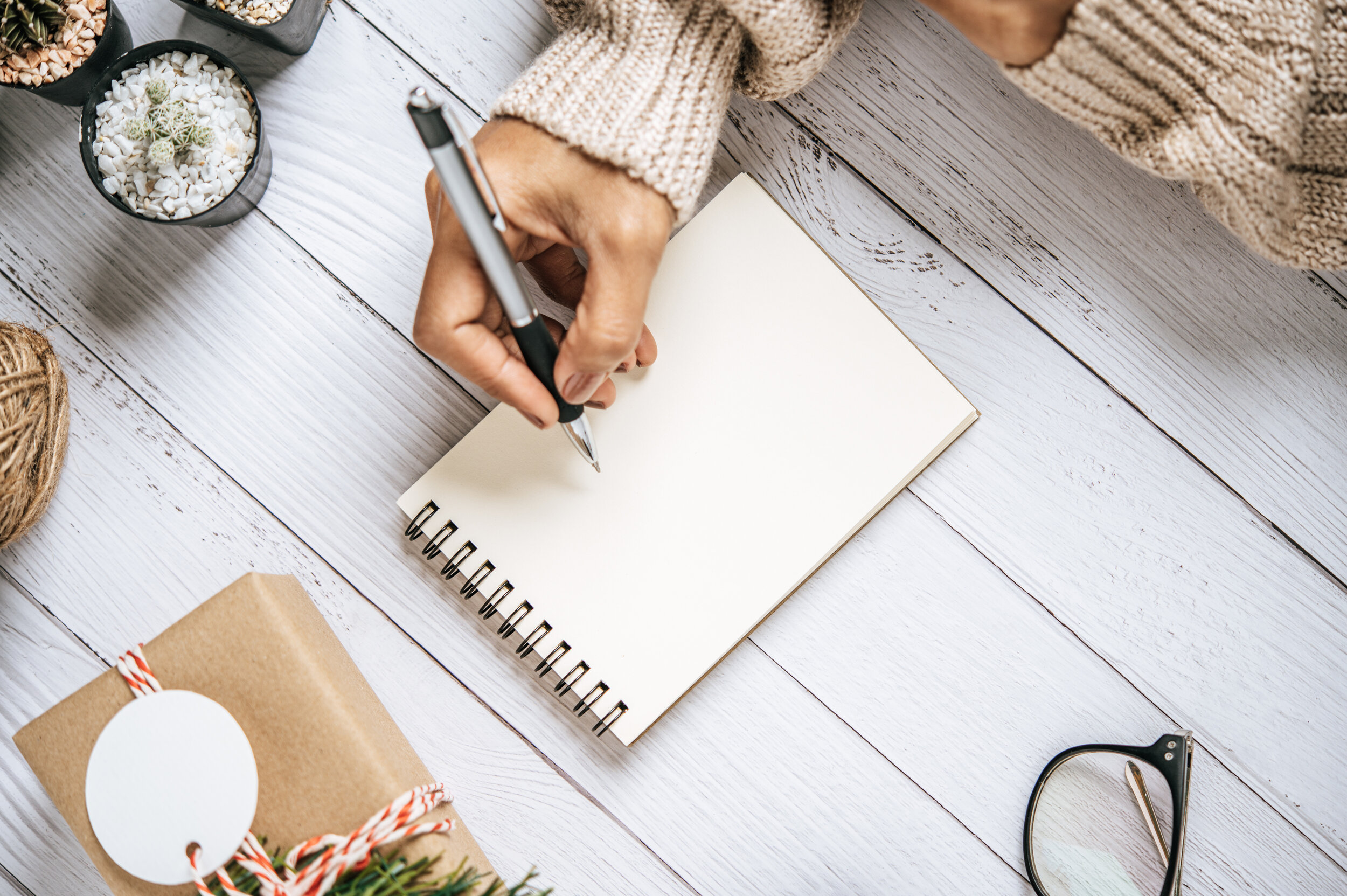 a-hand-holding-a-pen-to-write-on-a-notebook-with-g-FSNDR6M.jpg