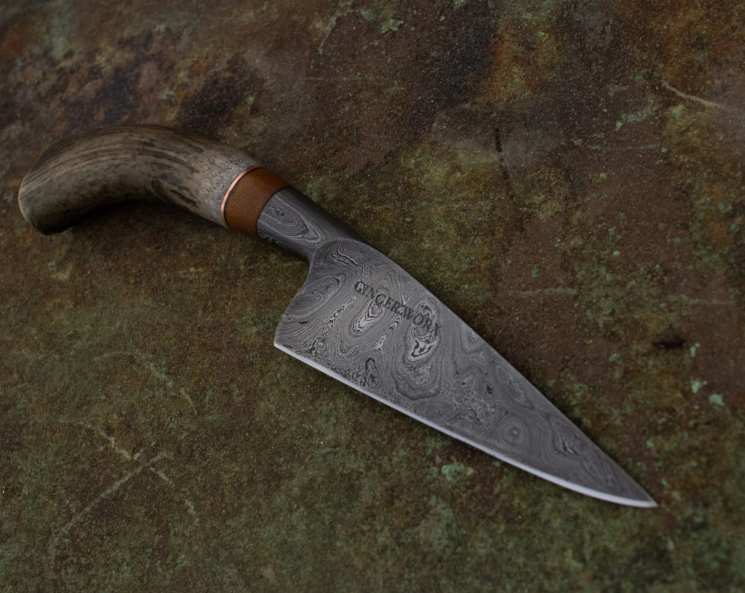 A Damascus steel knife with a deer antler handle