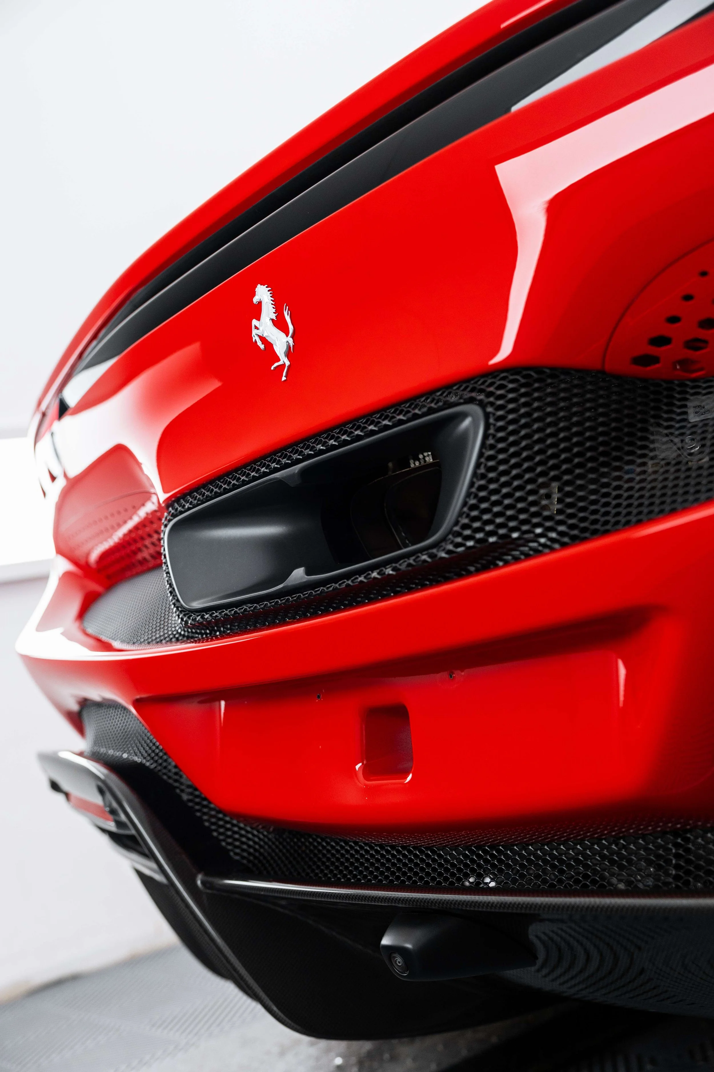 Red Ferrari 296 GTS windscreen edge and Ferrari badge with XPEL Windscreen Protection Film in Mona Vale