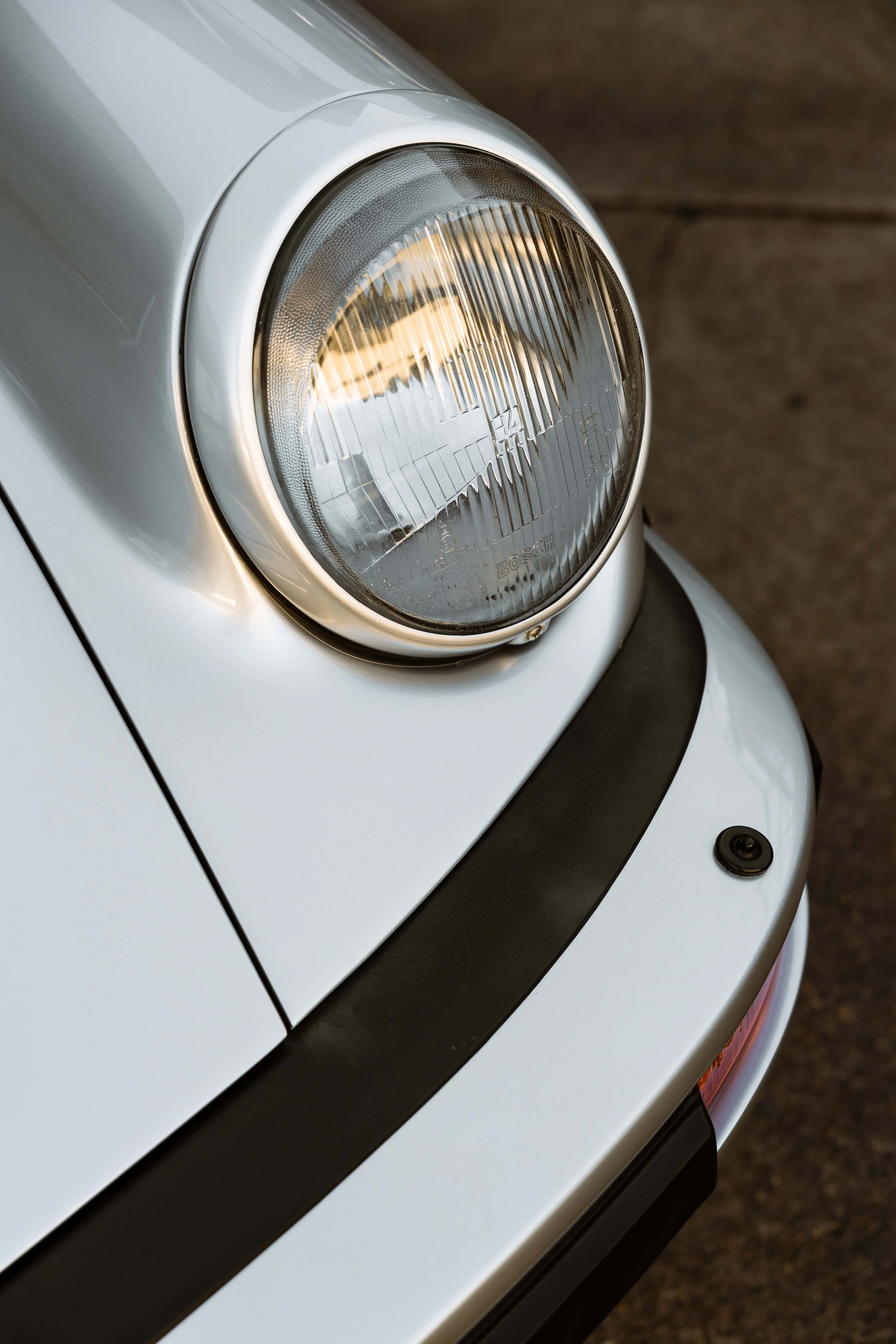 Silver 1989 Porsche 911 Carrera Targa headlight and front guard with XPEL Paint Protection Film in Sydney