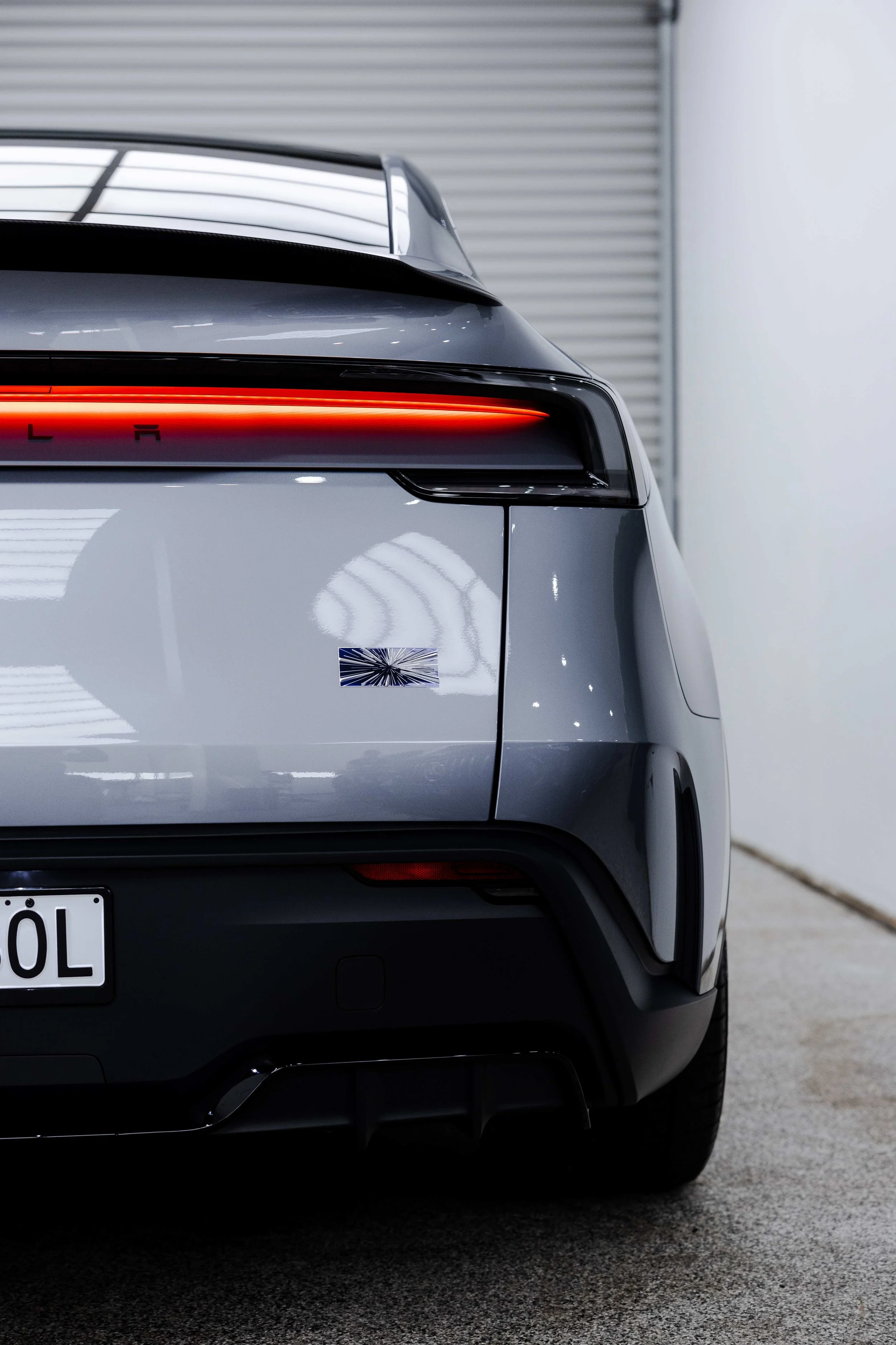 Silver Tesla Model Y rear light bar and badge close up with XPEL Paint Protection Film in Mona Vale