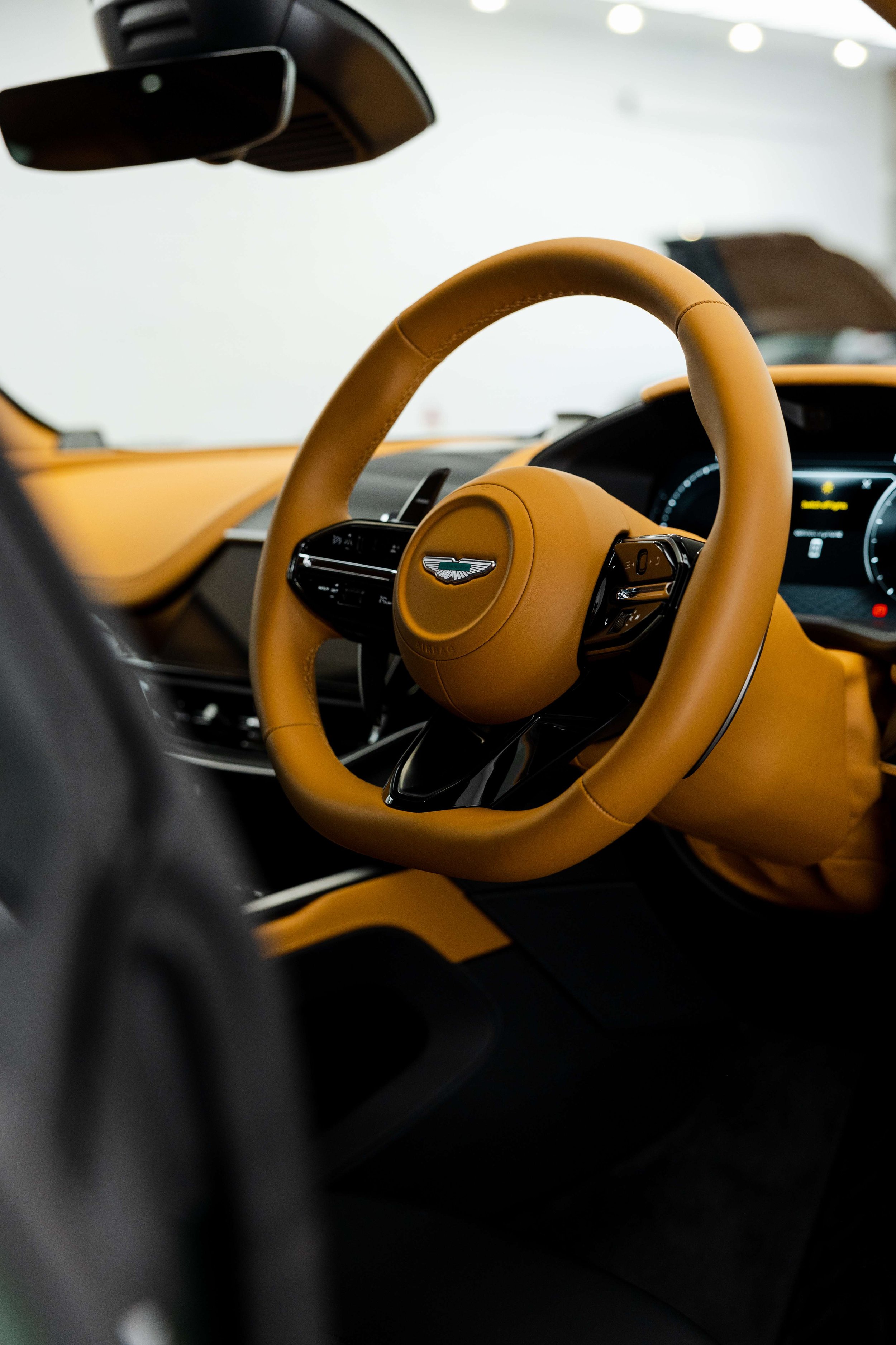 Matte green Aston Martin DBX interior detailing tan leather steering wheel in Sydney