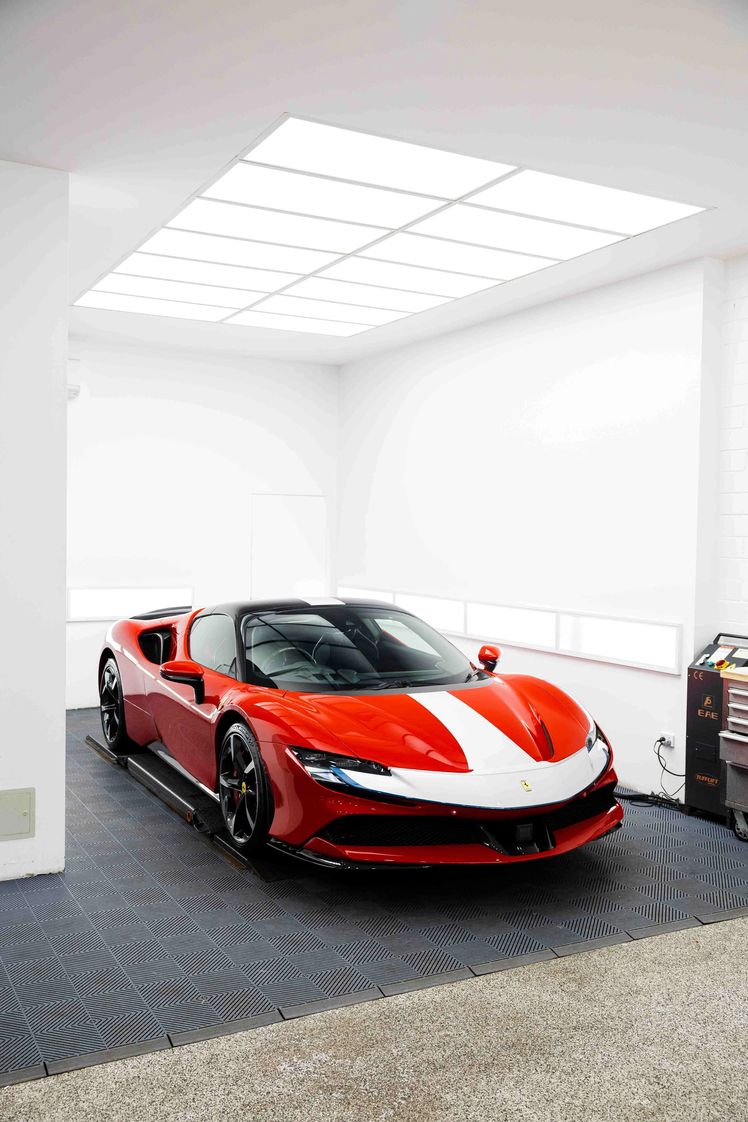 Red Ferrari SF90 Spyder front three quarter in studio with white stripe and XPEL Paint Protection Film in Sydney