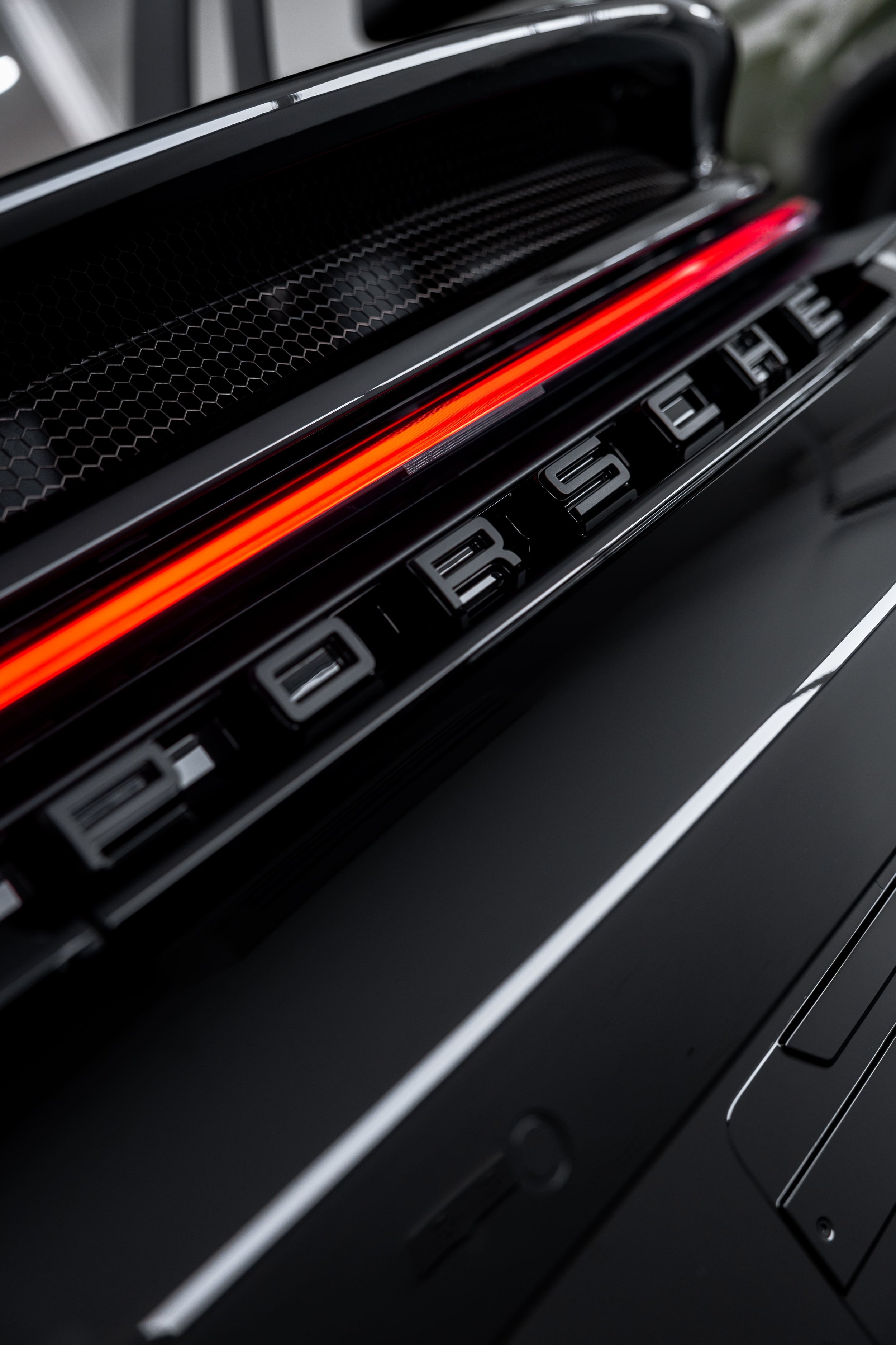 Close-up of Porsche 911 GT3 rear with illuminated LED light bar and Porsche lettering, showcasing flawless finish protected with PPF by ADS