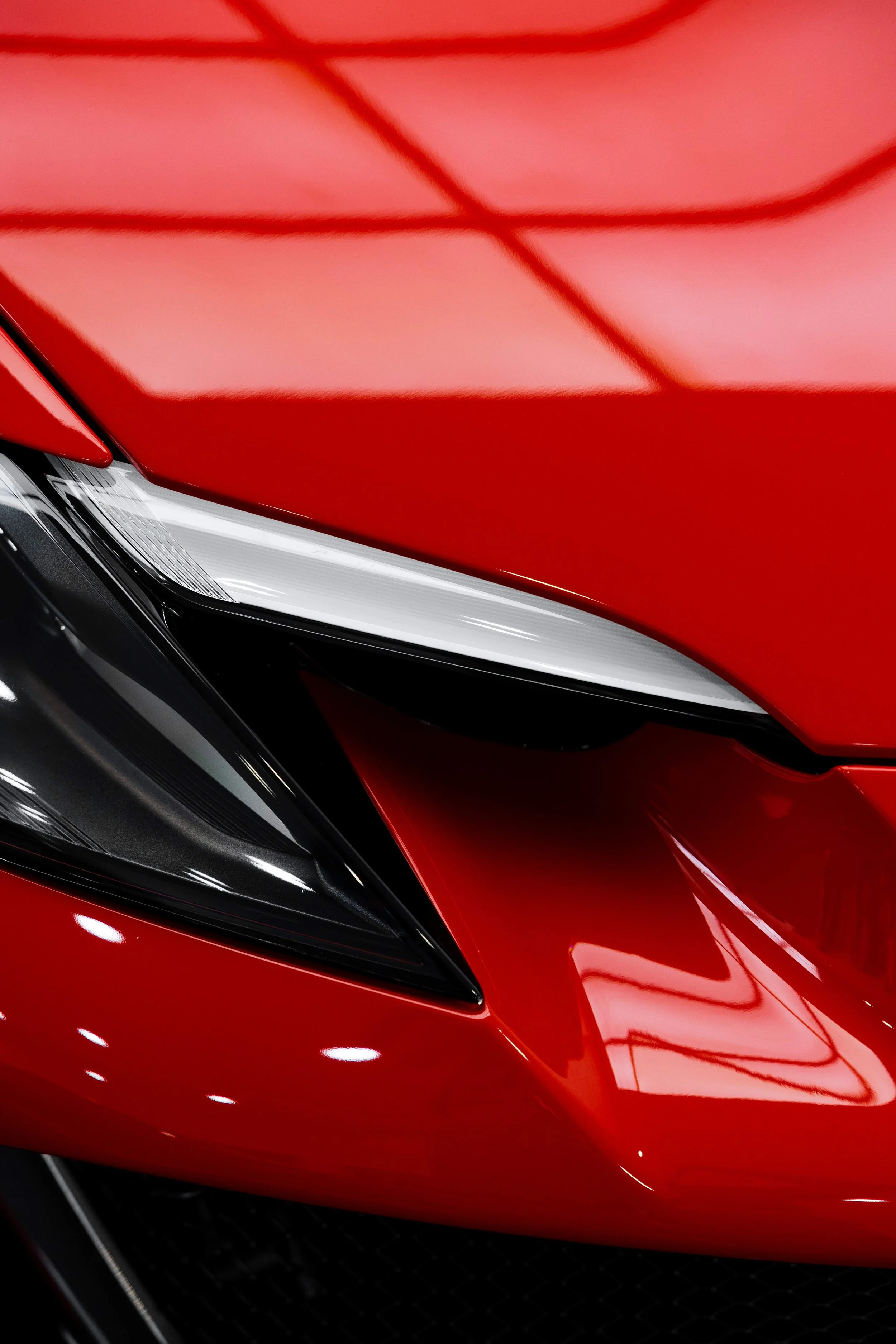 Red Ferrari 296 Speciale headlight and front quarter close up with XPEL Paint Protection Film in Mona Vale
