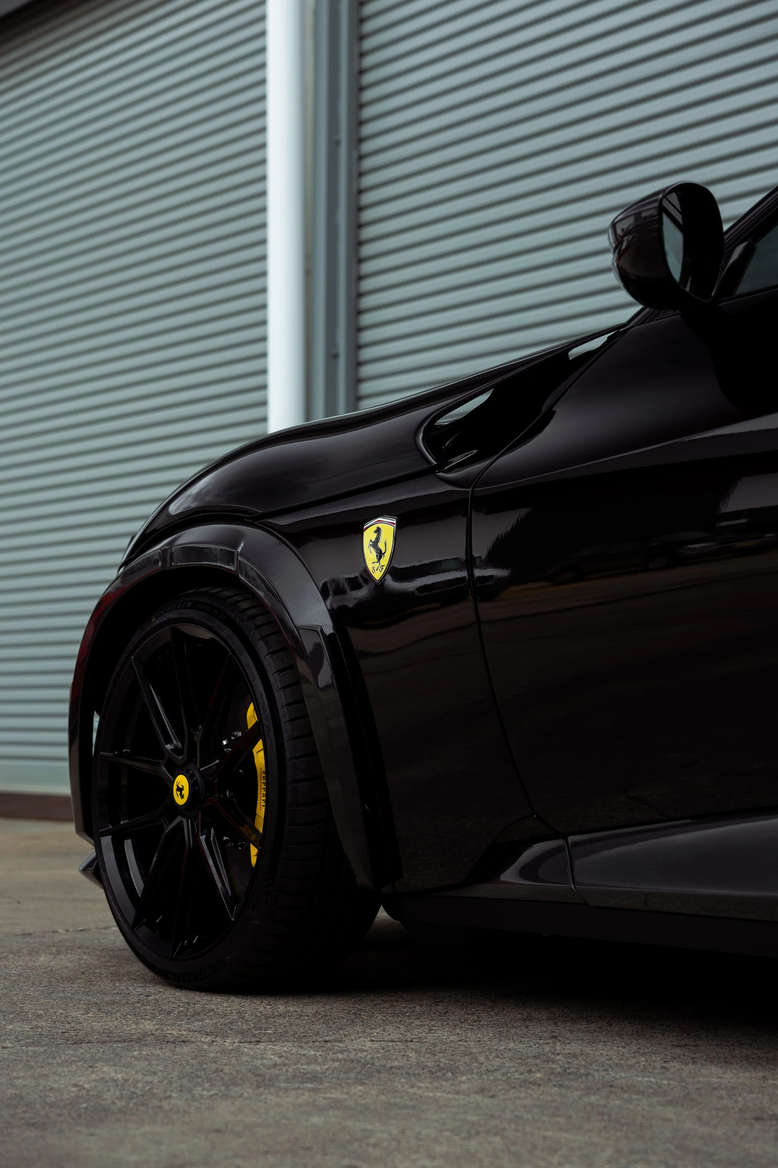 Ferrari Purosangue front quarter panel and wheel detail in gloss black with yellow brake calipers, protected by PPF by Australian Detailing Services Sydney