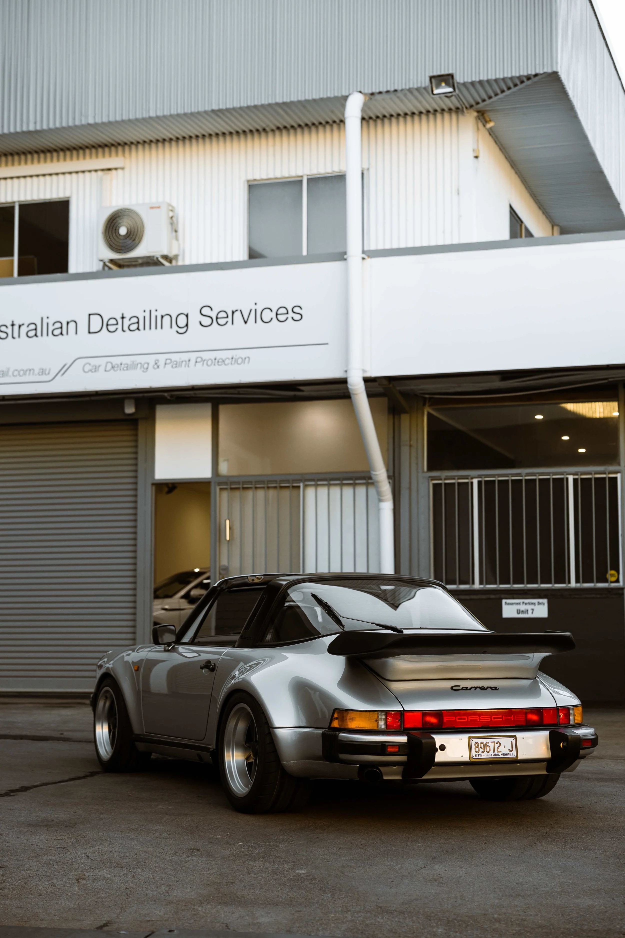 Silver 1989 Porsche 911 Carrera Targa rear quarter outside Australian Detailing Services in Sydney