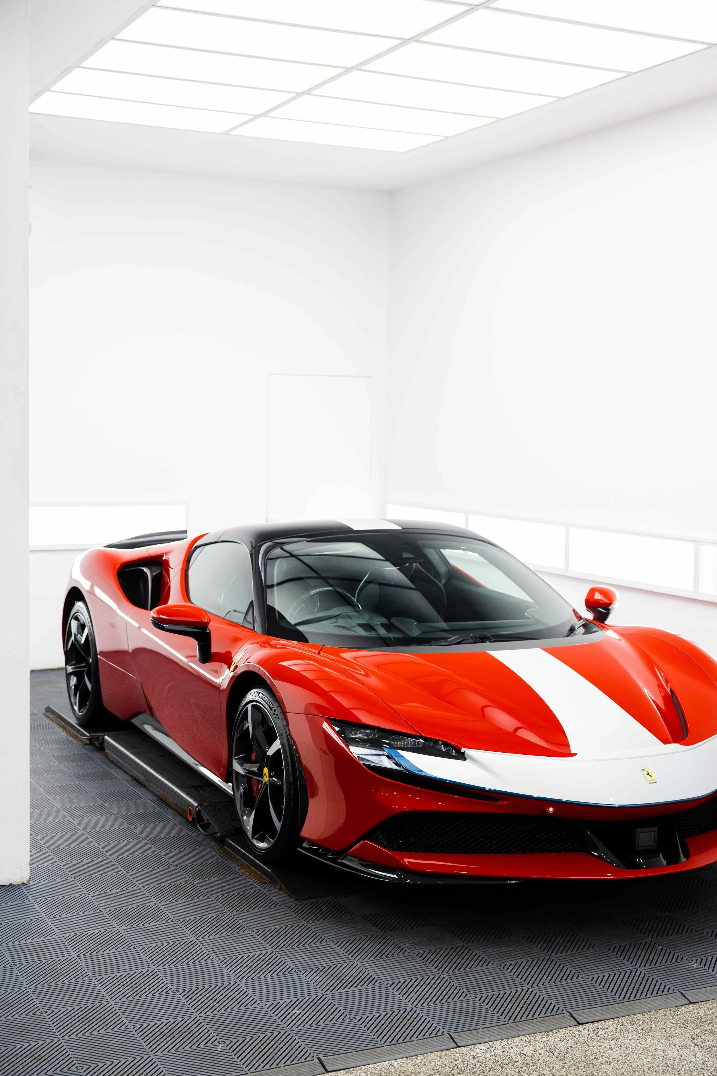 Red Ferrari SF90 Spyder front three quarter in studio with white stripe and XPEL Paint Protection Film in Mona Vale
