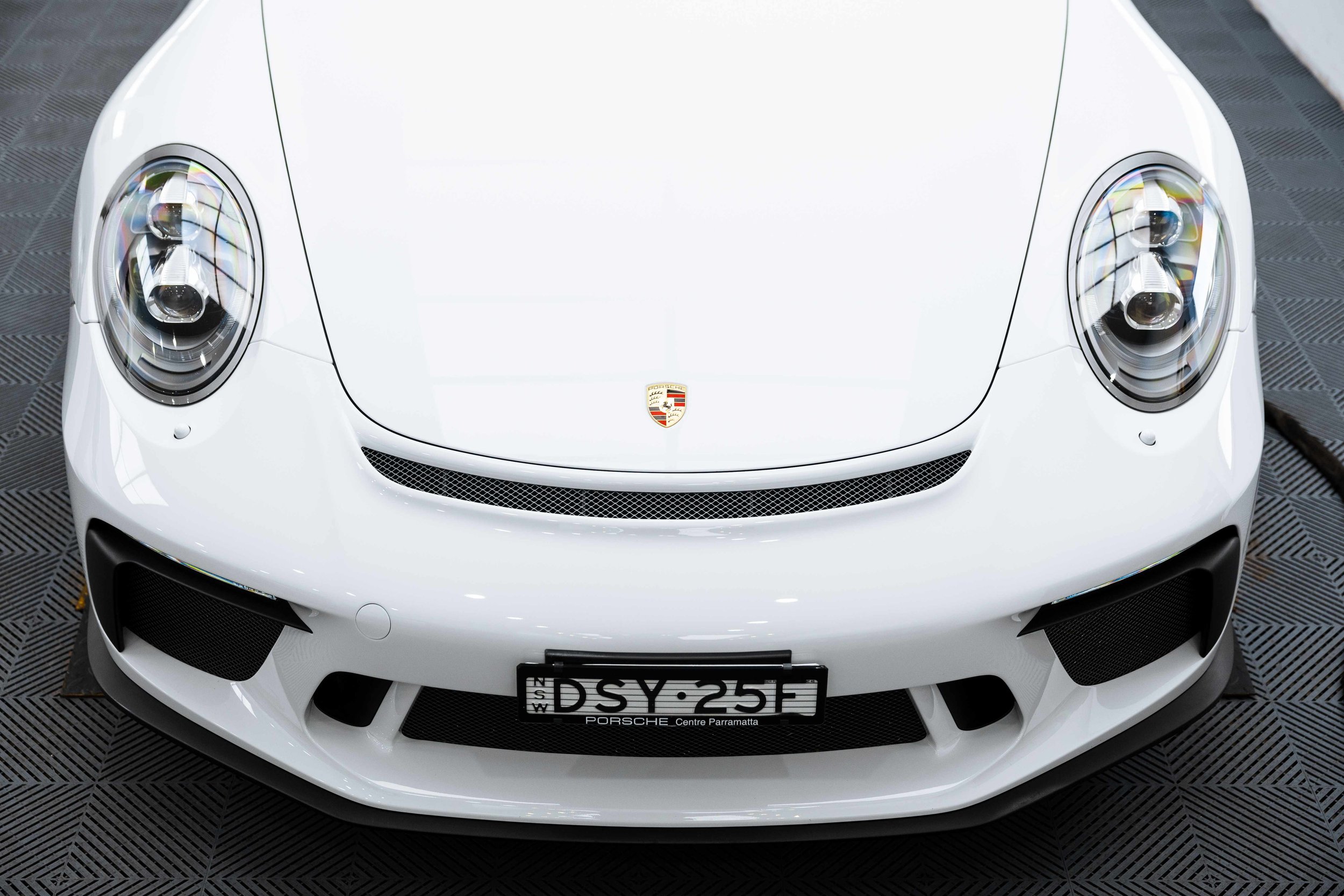 White Porsche GT3 front headlight and badge close up with XPEL Paint Protection Film in Mona Vale