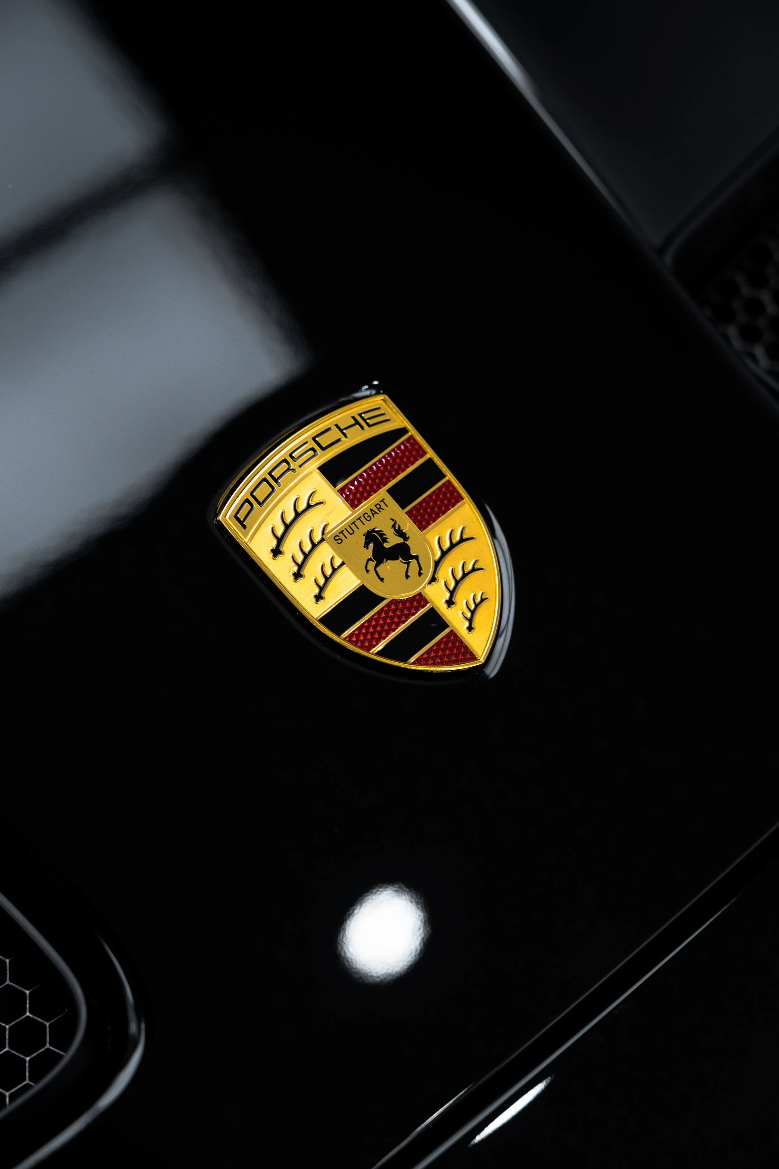Close-up of Porsche 911 GT3 bonnet badge on gloss black paint, showcasing pristine finish and PPF protection by ADS