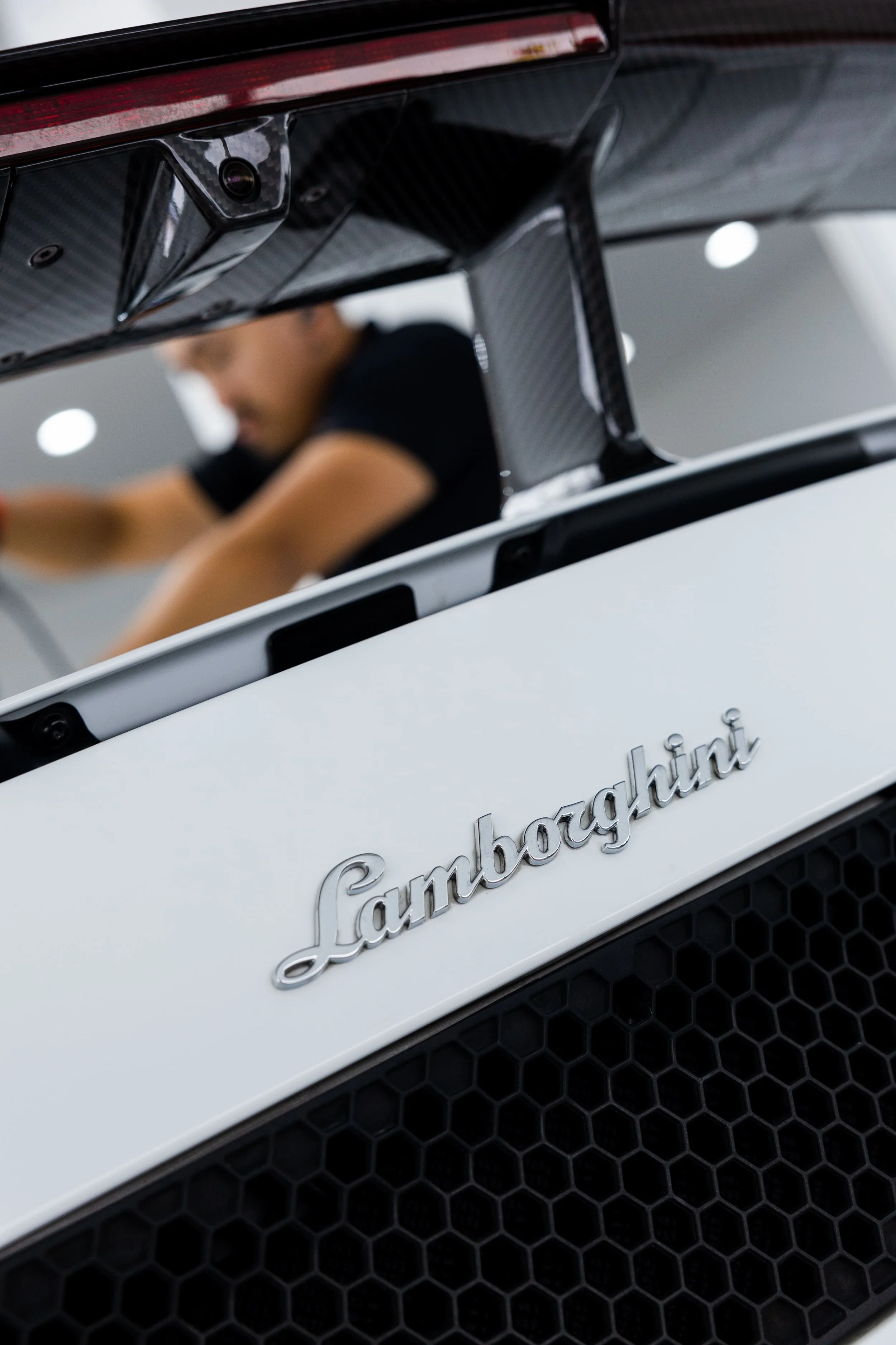Lamborghini Gallardo rear badge detail with carbon fibre wing and honeycomb grille in detailing studio