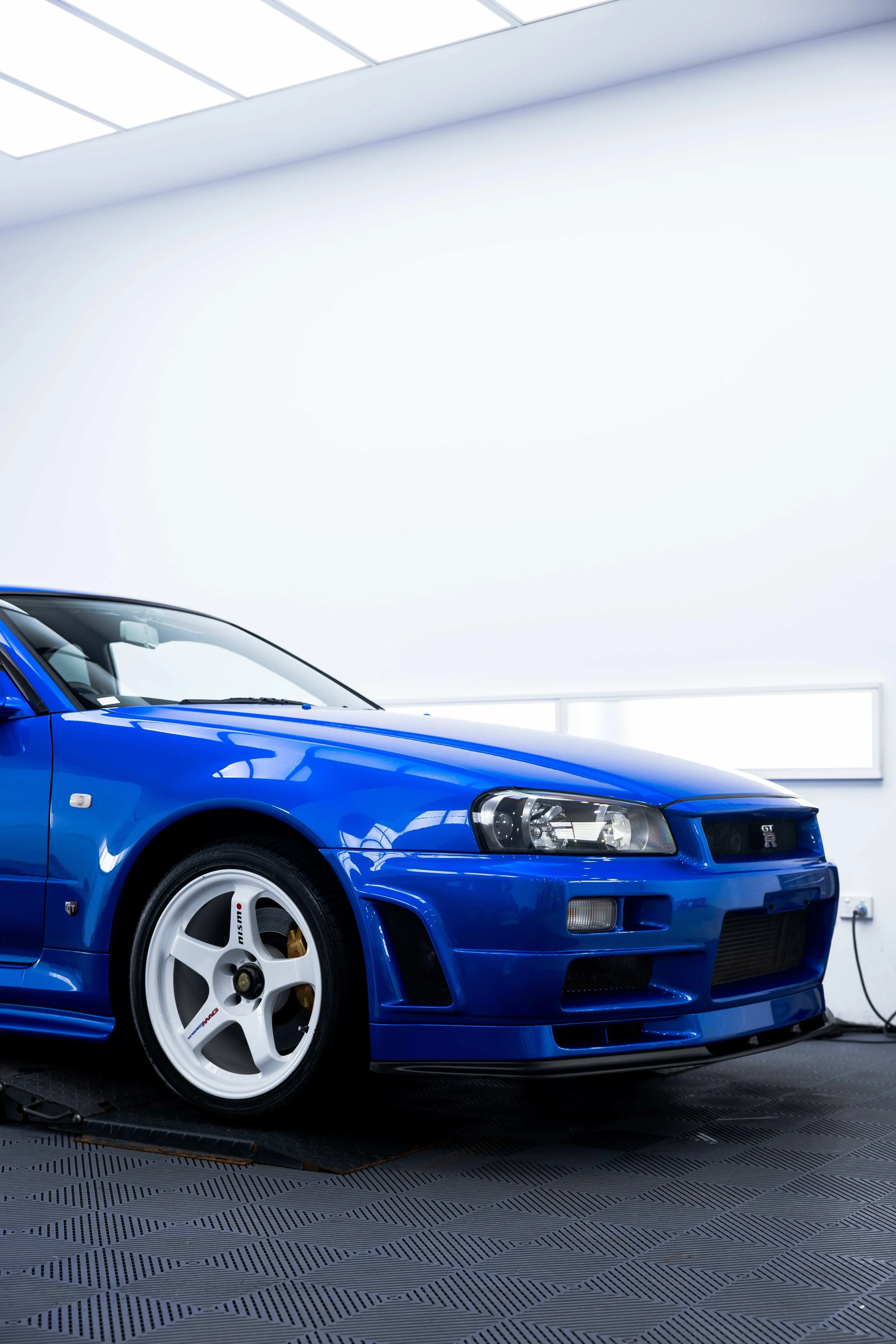 Bayside blue Nissan R34 GT-R Nur front three quarter view with XPEL Paint Protection Film in Sydney