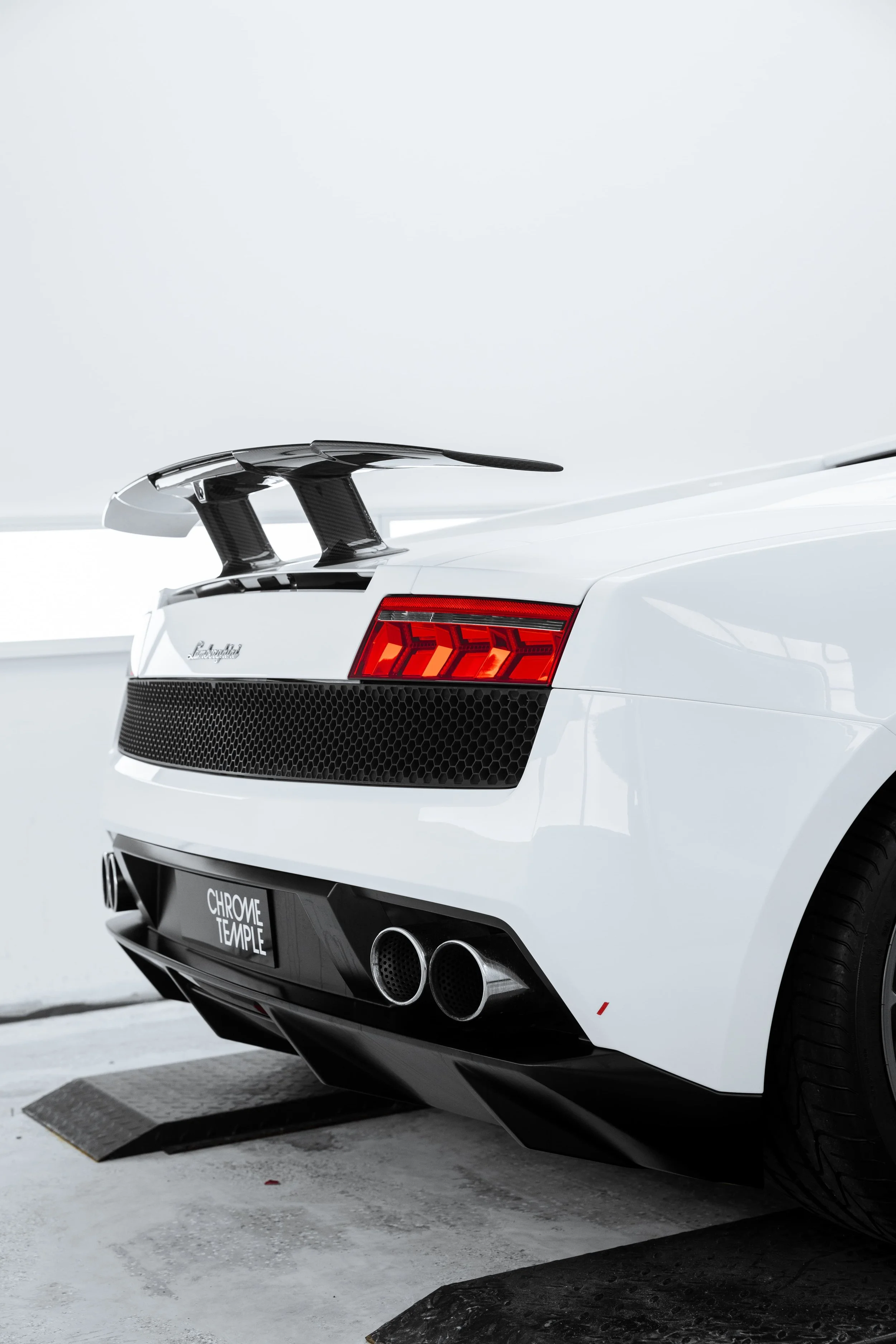 White Lamborghini Gallardo rear view with taillights, exhaust and carbon wing detail protected with full PPF by ADS in Mona Vale