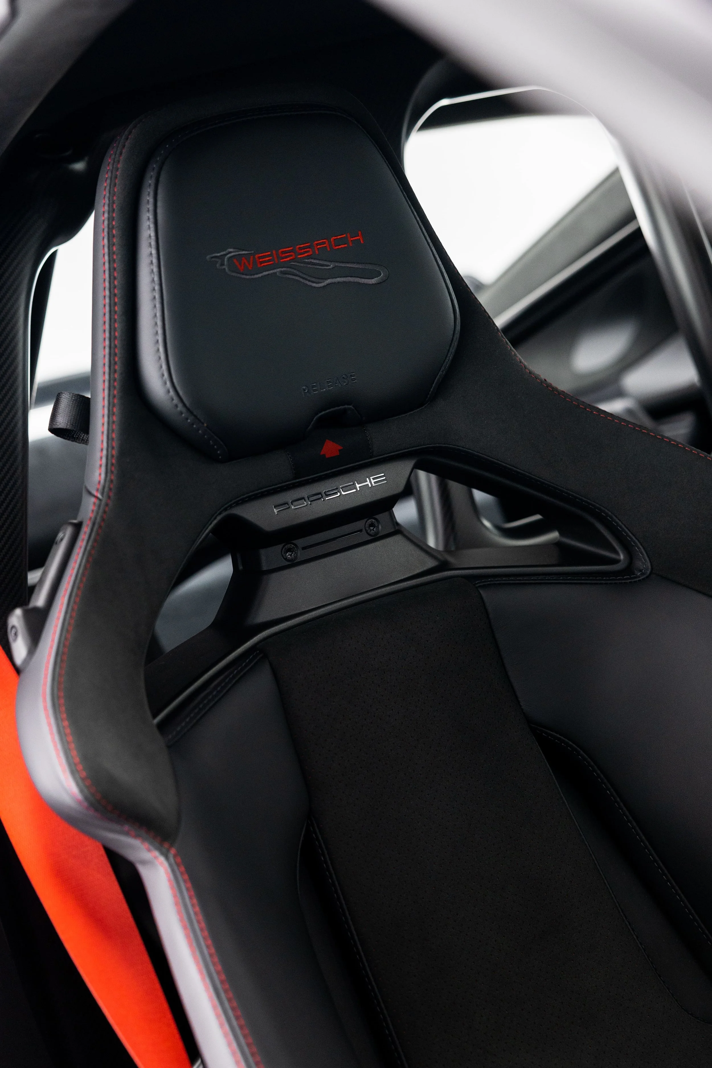 Close-up of Porsche 911 GT3 bucket seat with Weissach package logo, black leather and Alcantara with red stitching and carbon fibre shell