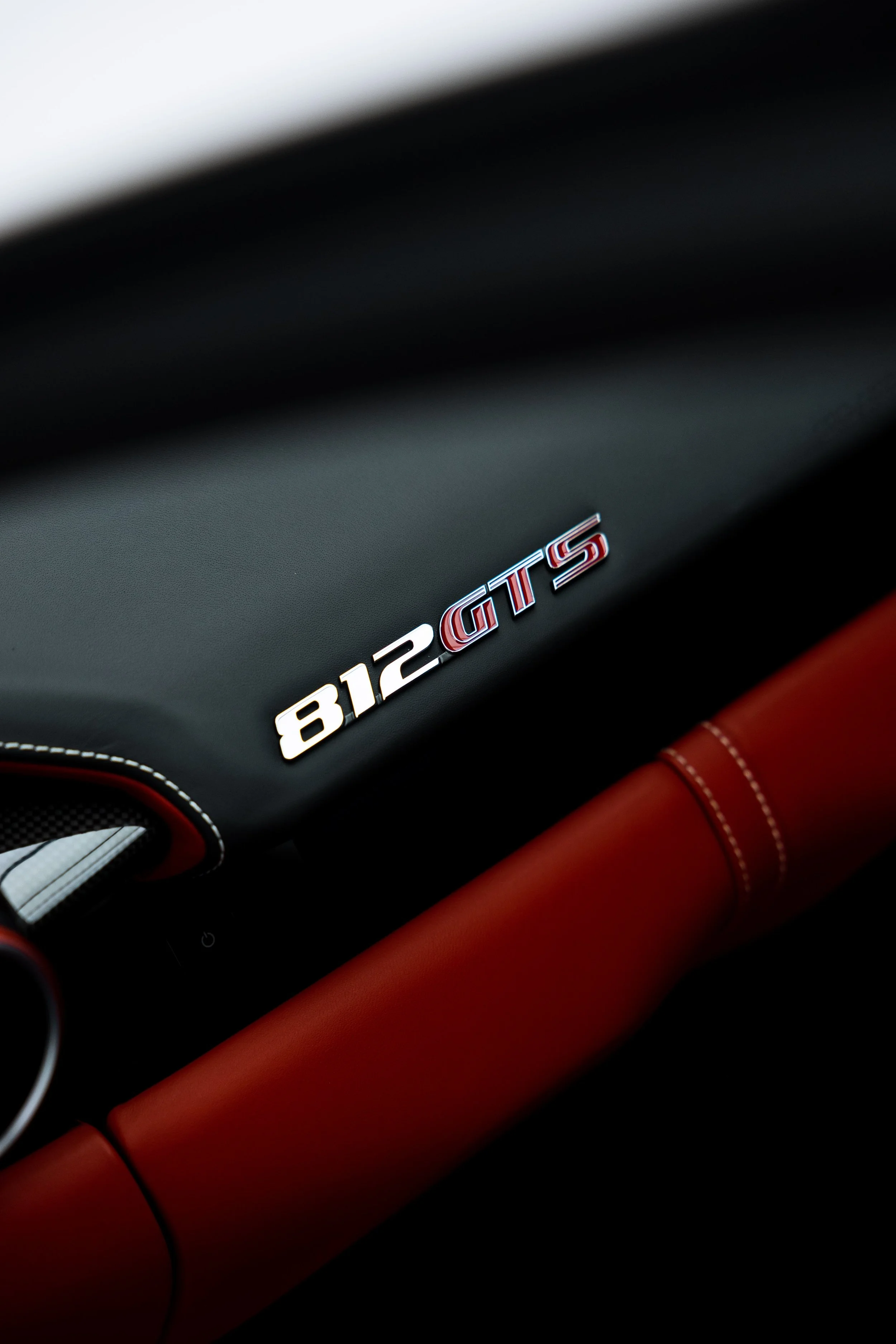 White Ferrari 812 GTS interior detailing dash badge and red leather trim in Sydney