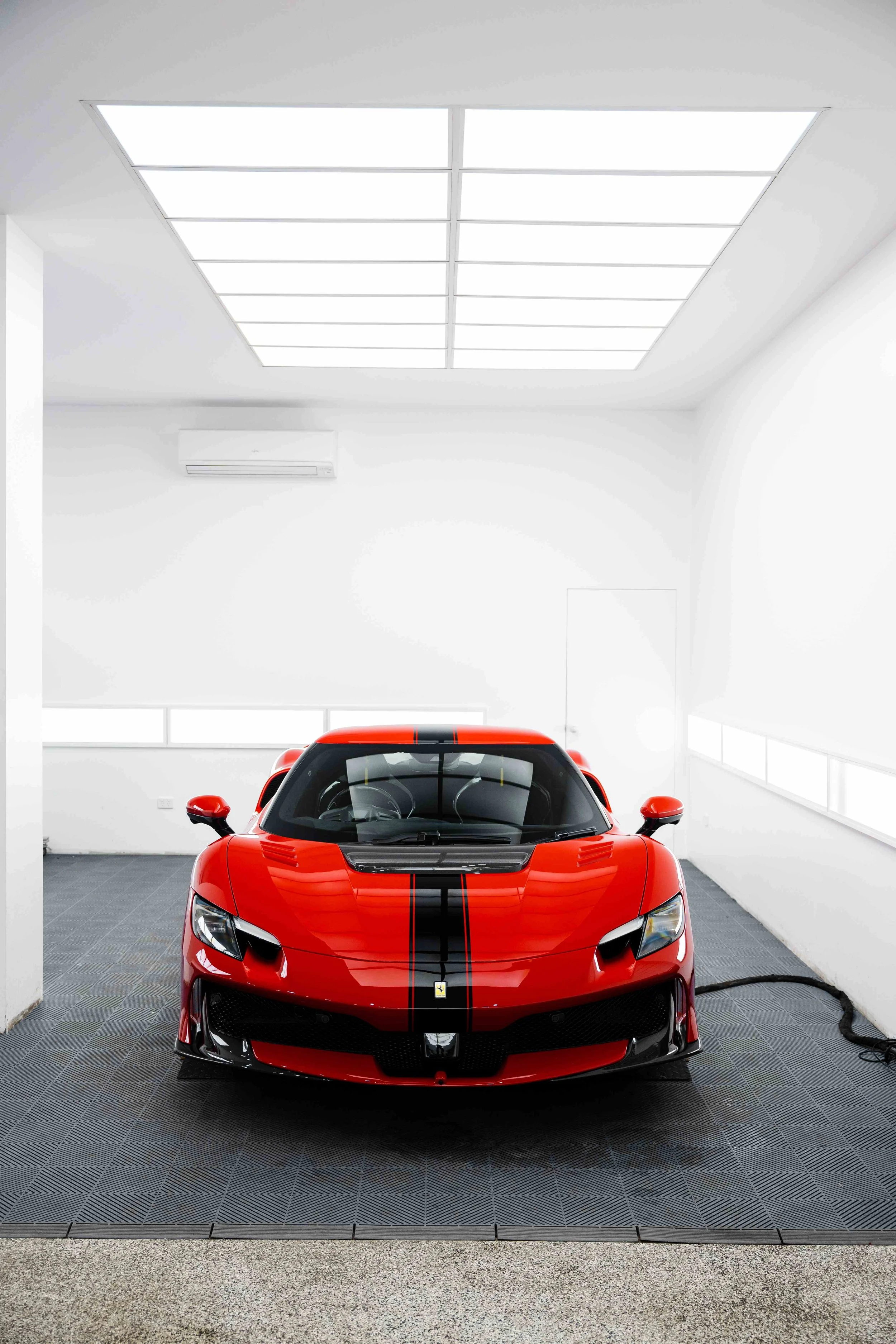 Red Ferrari 296 Speciale front view in studio with black racing stripe and XPEL Paint Protection Film in Sydney