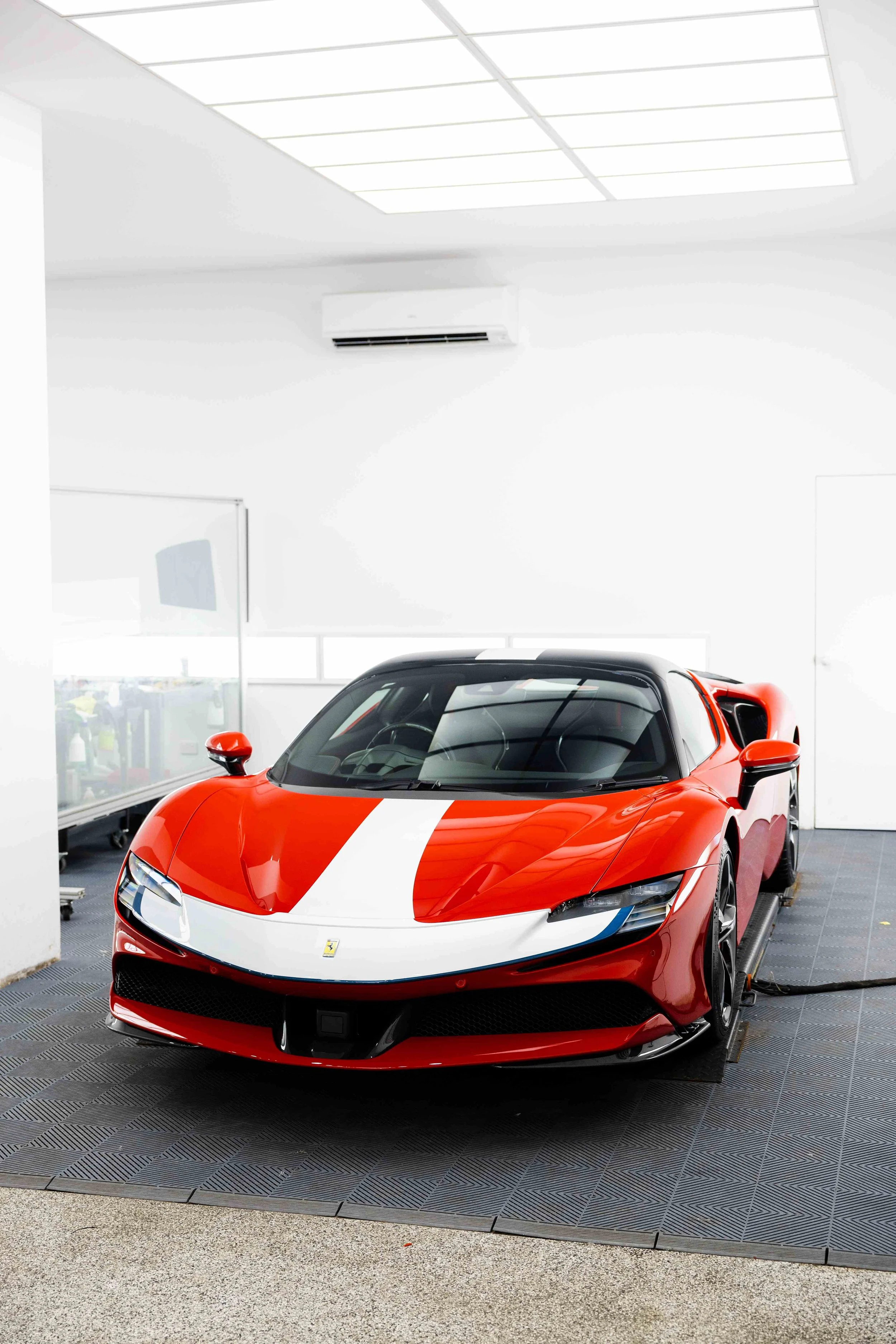 Red Ferrari SF90 Spyder front three quarter in studio with white stripe and XPEL Paint Protection Film in Mona Vale