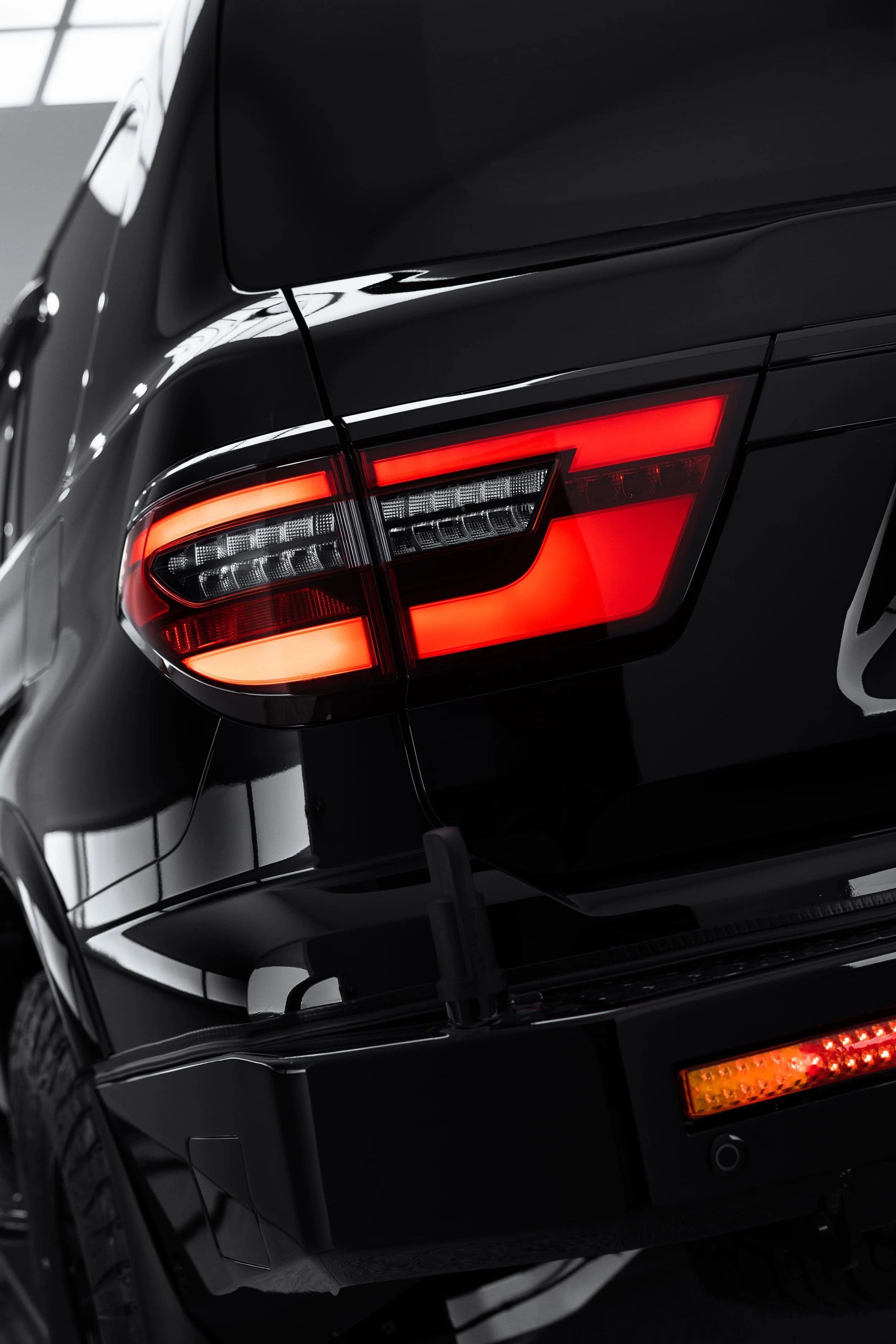 Rear three-quarter view of Y62 Nissan Patrol tail light and glossy black paint after detailing by ADS in Sydney