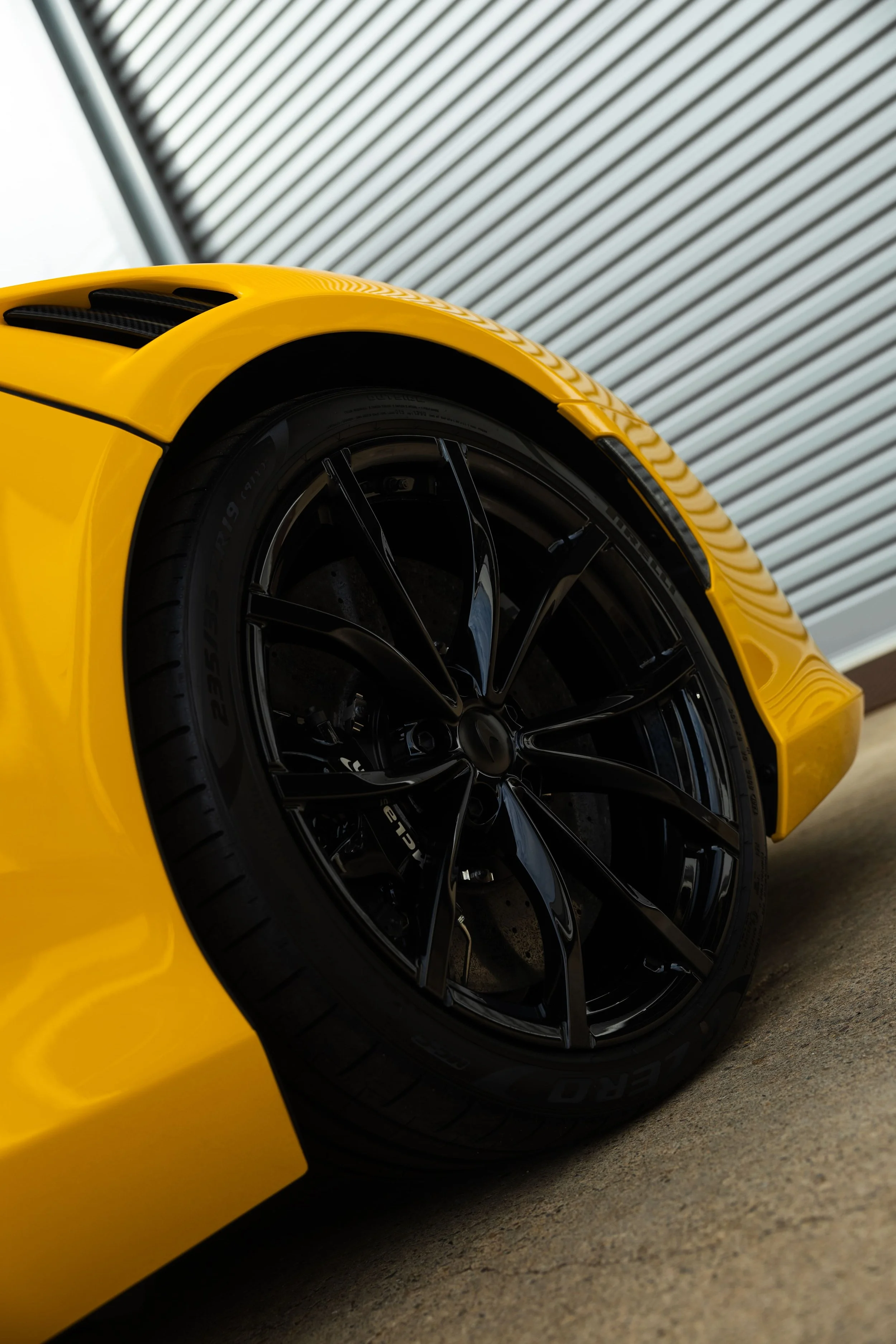 Yellow McLaren Artura front wheel detail with black rims and PPF protection by ADS in Mona Vale