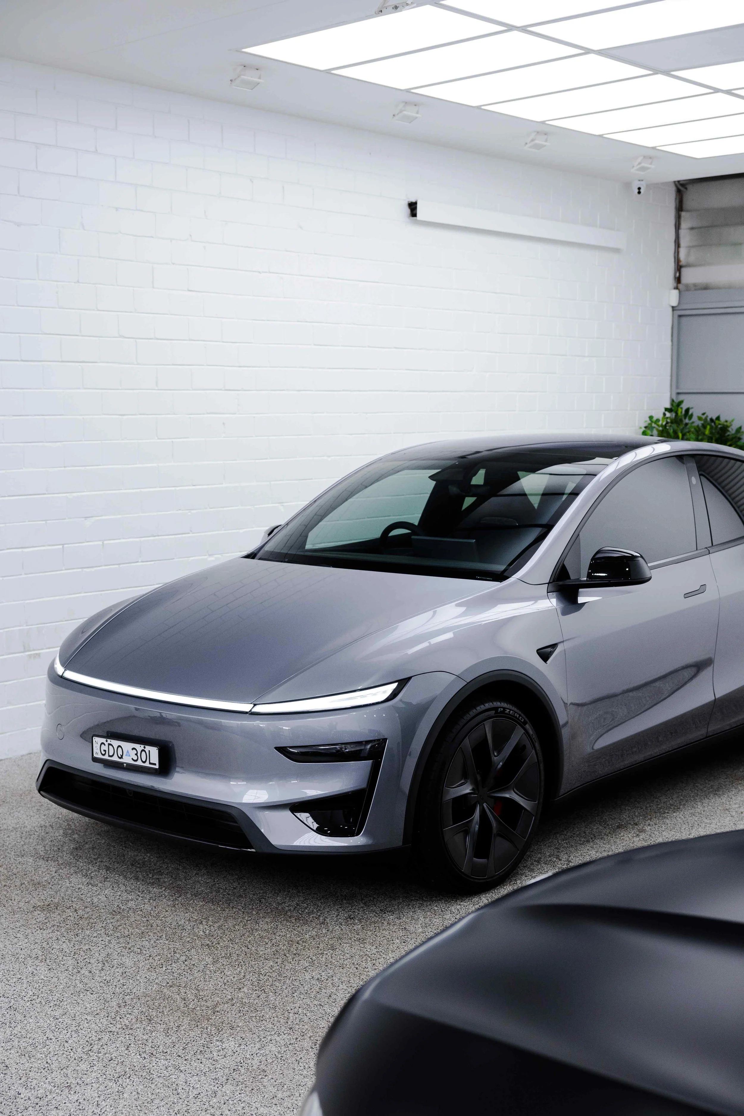 Silver Tesla Model Y front three quarter in studio with XPEL Paint Protection Film in Mona Vale