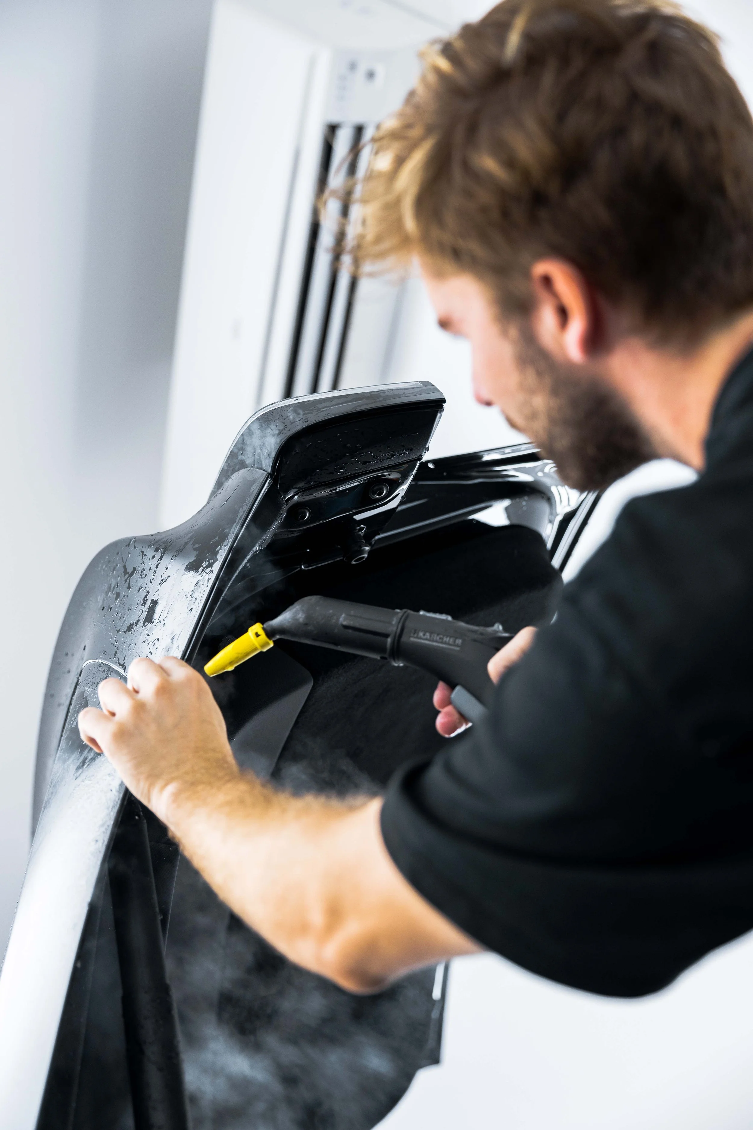 ADS technician applying XPEL Stealth Paint Protection Film to Tesla Model Y front guard in Sydney