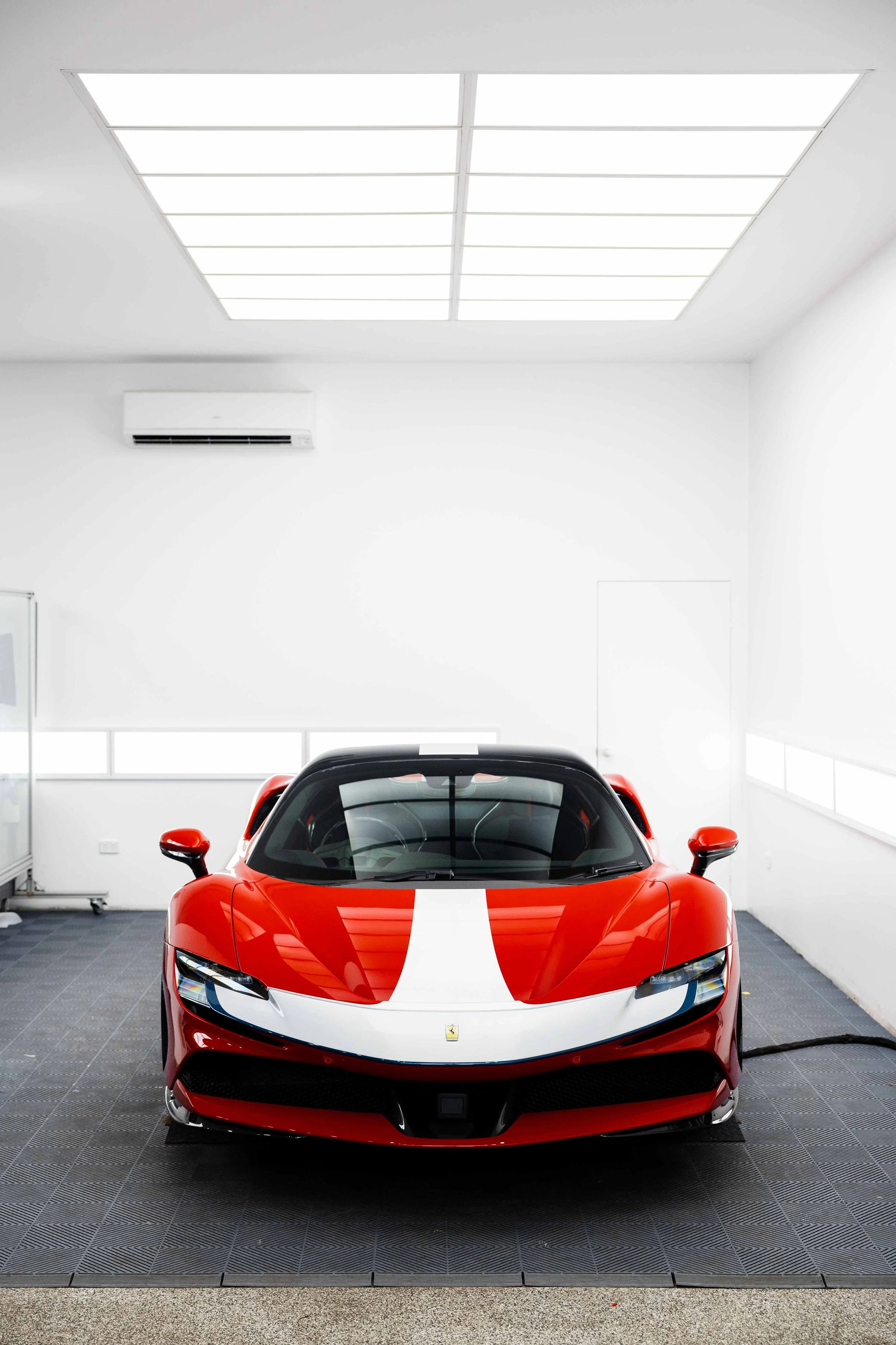 Red Ferrari SF90 Spyder front view in studio with white stripe and XPEL Paint Protection Film in Sydney
