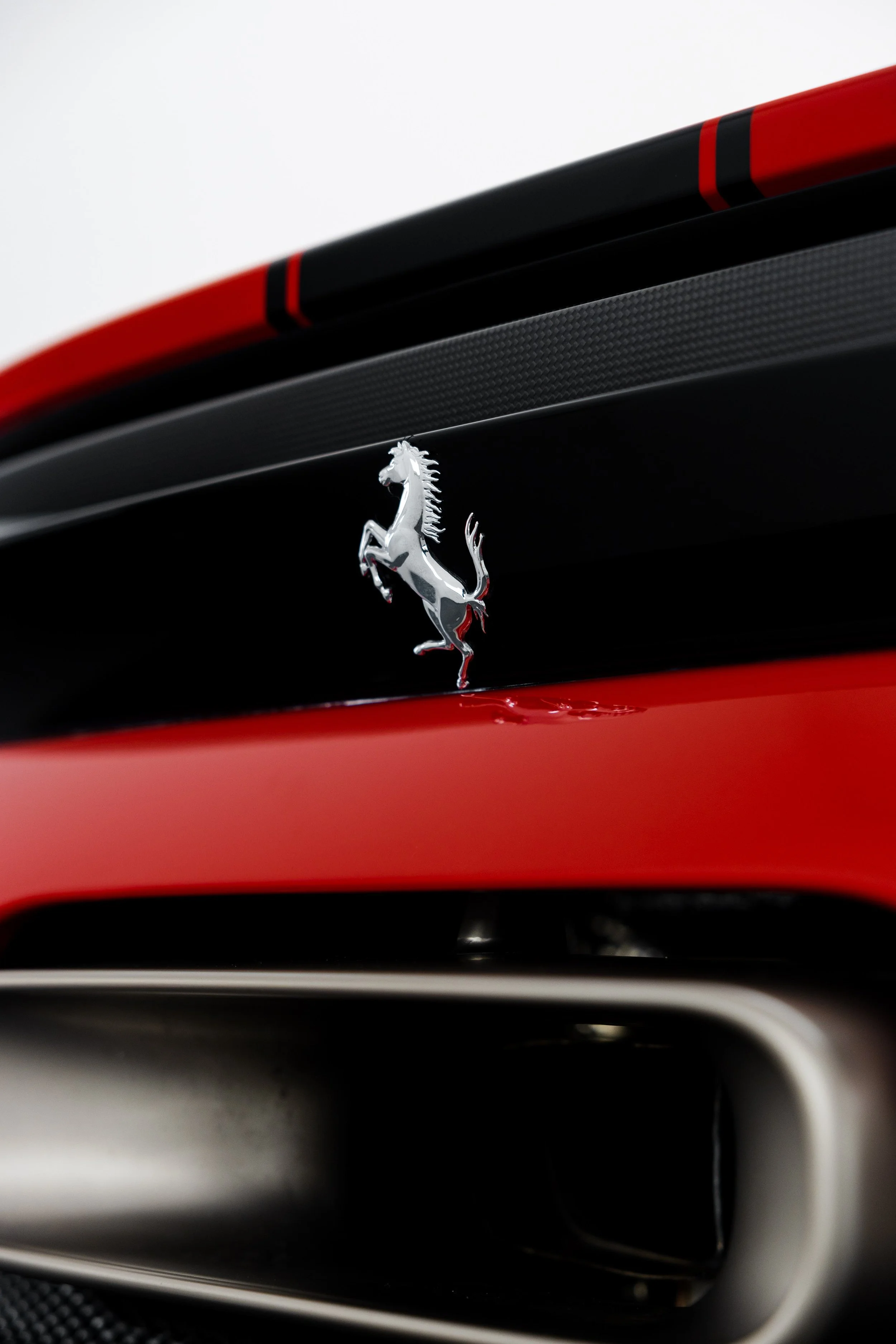 Red Ferrari 296 Speciale rear Prancing Horse badge on black stripe and exhaust outlet in Mona Vale
