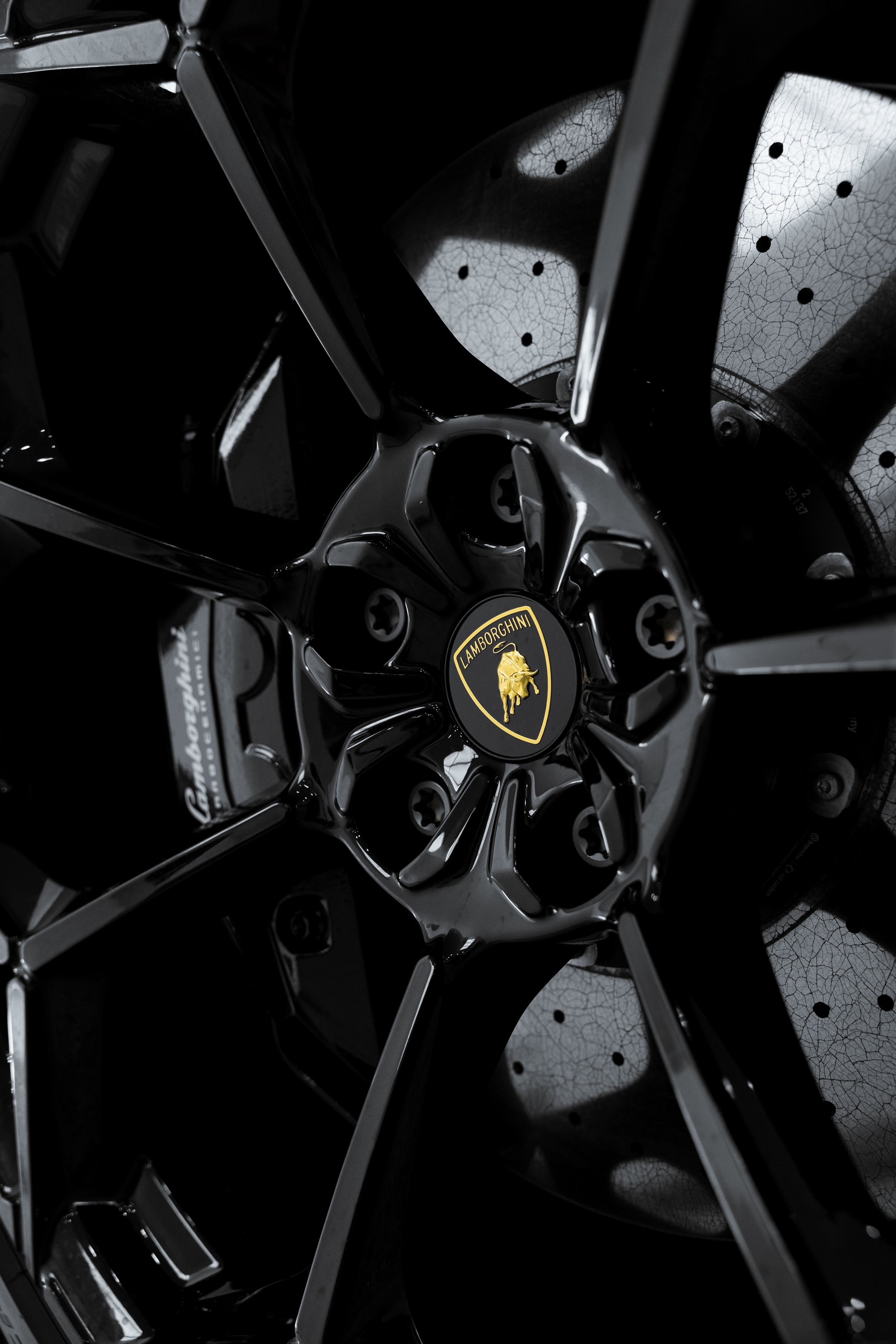 Close-up of Lamborghini Urus black alloy wheel and brake disc with PPF protection by ADS in Sydney