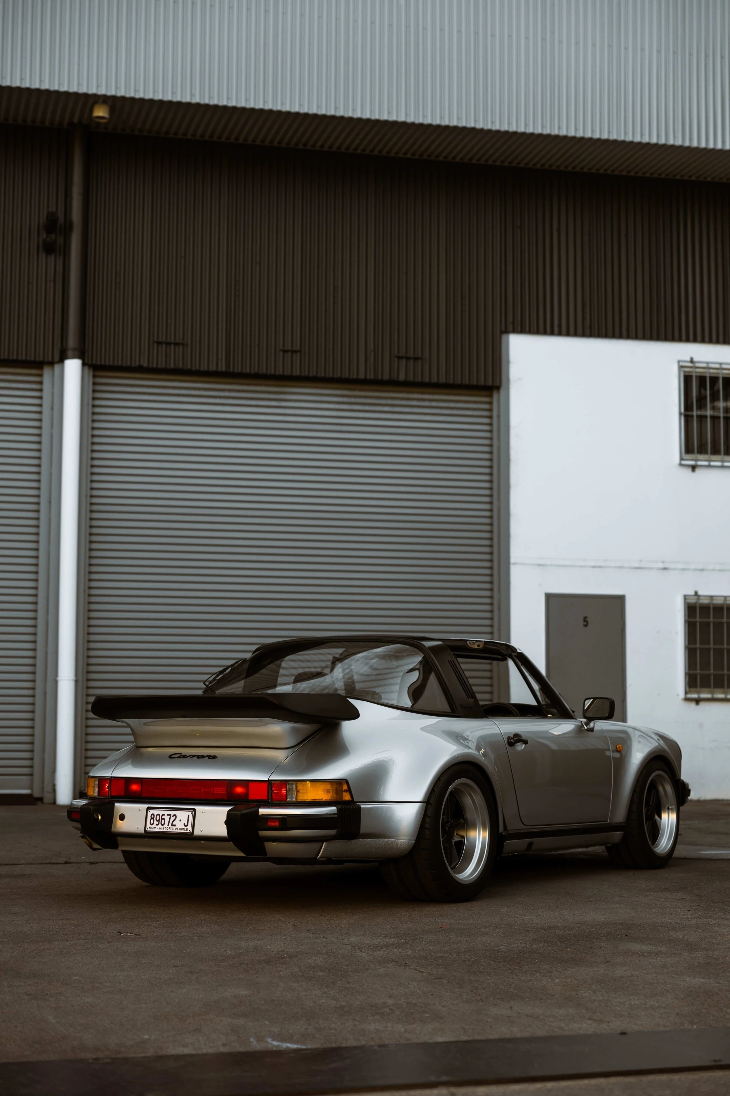 Silver 1989 Porsche 911 Carrera Targa rear three quarter outside Australian Detailing Services in Mona Vale