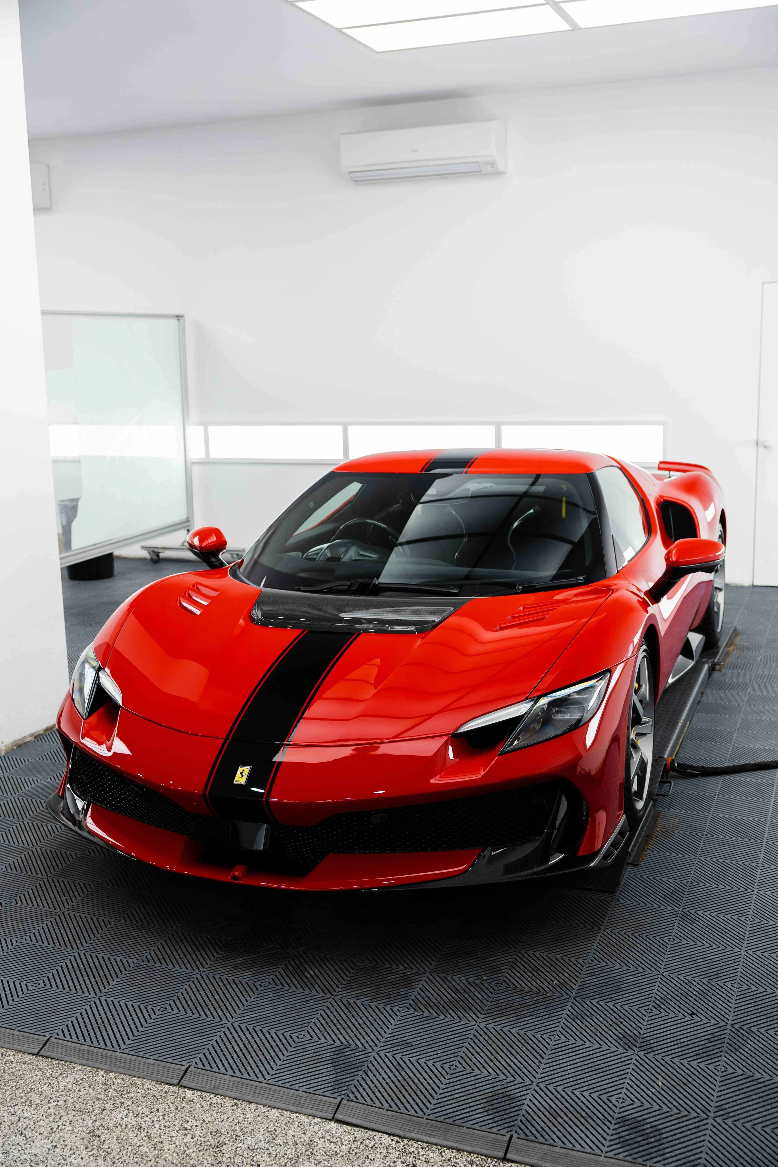 Red Ferrari 296 Speciale front three quarter in studio with black racing stripe and XPEL Paint Protection Film in Sydney