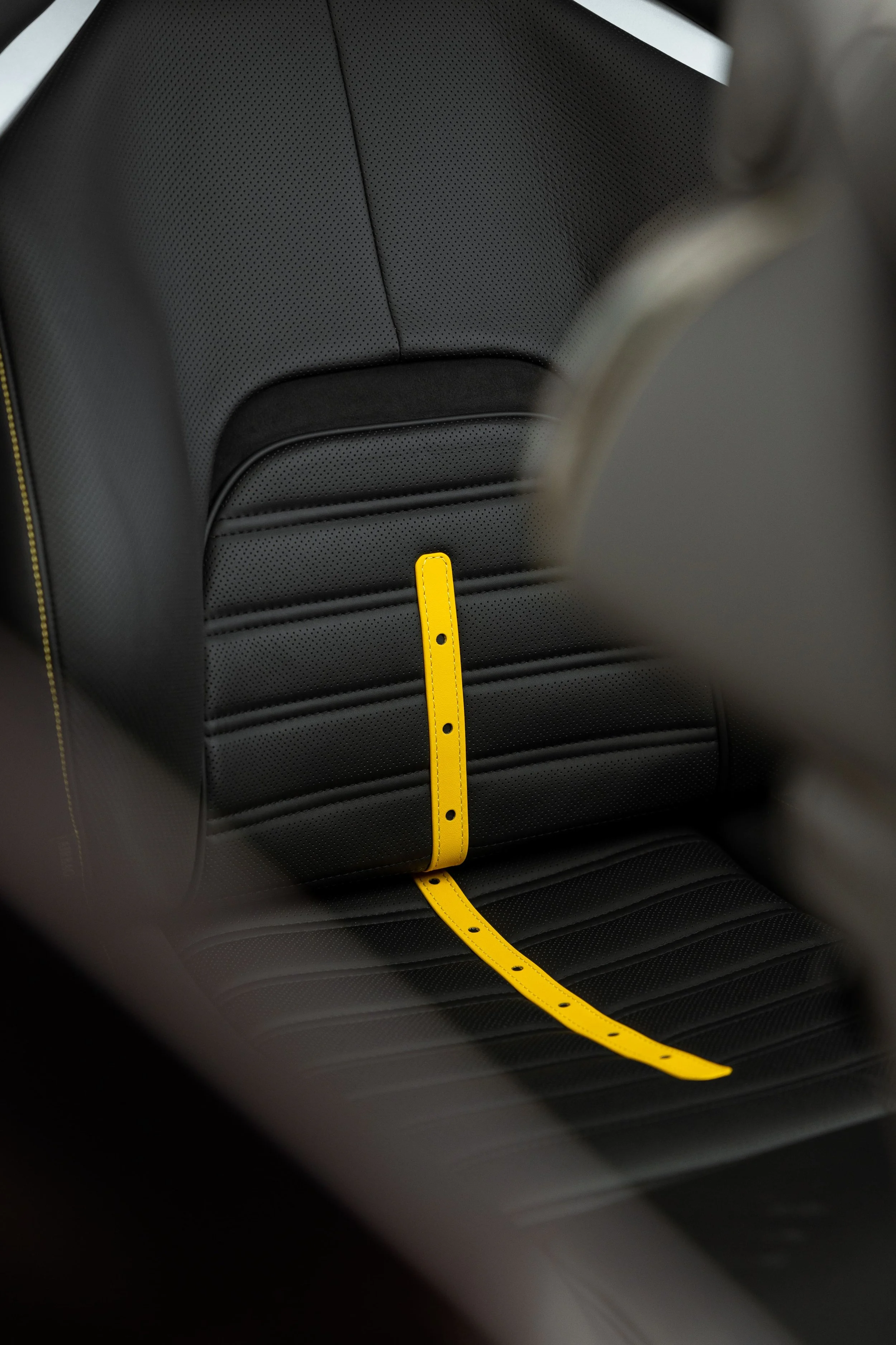 Ferrari Purosangue black leather seat detail with yellow accent strap and stitching, showcasing luxury interior protected by Australian Detailing Services Sydney