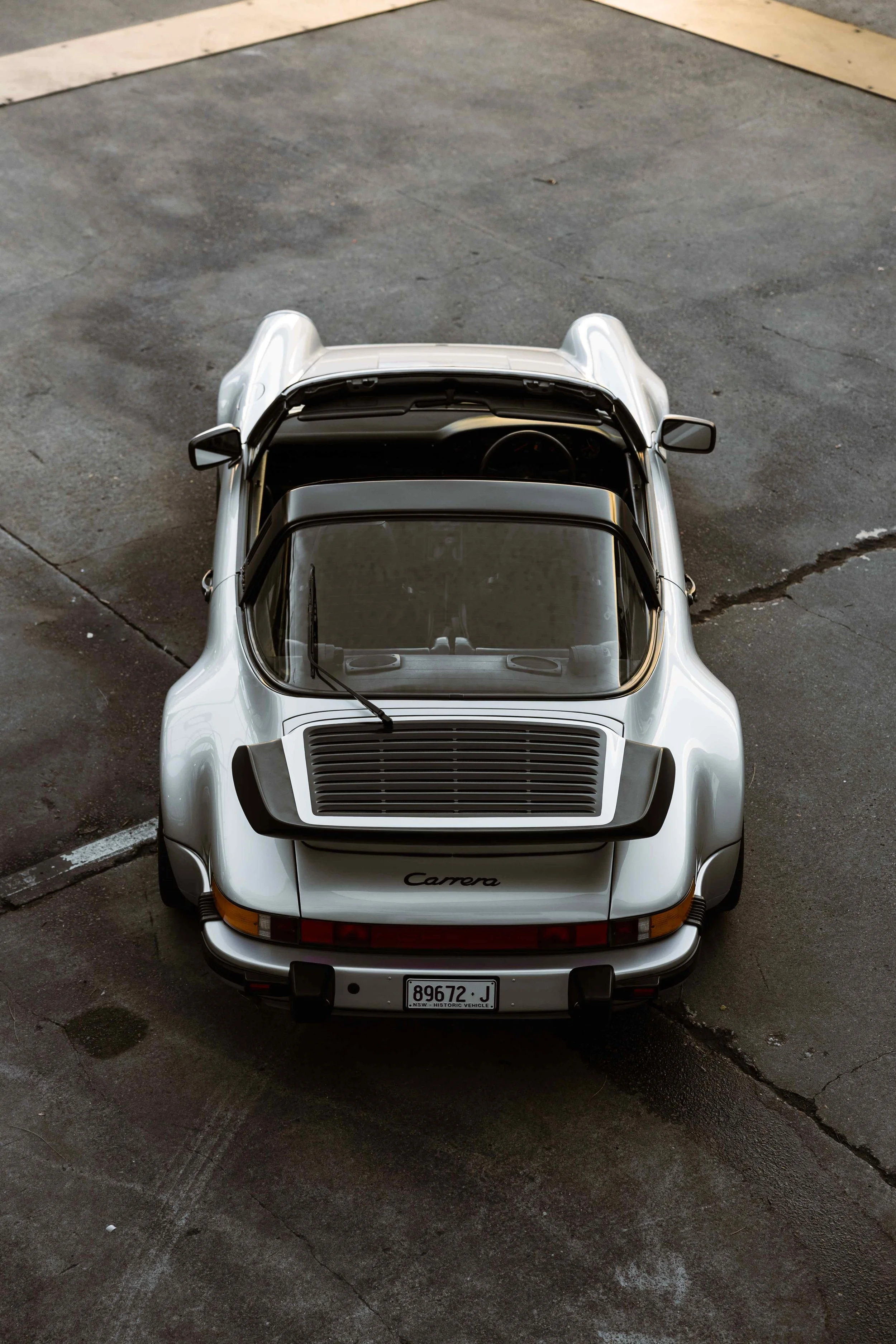 Silver 1989 Porsche 911 Carrera Targa aerial rear view with Carrera badge in Sydney