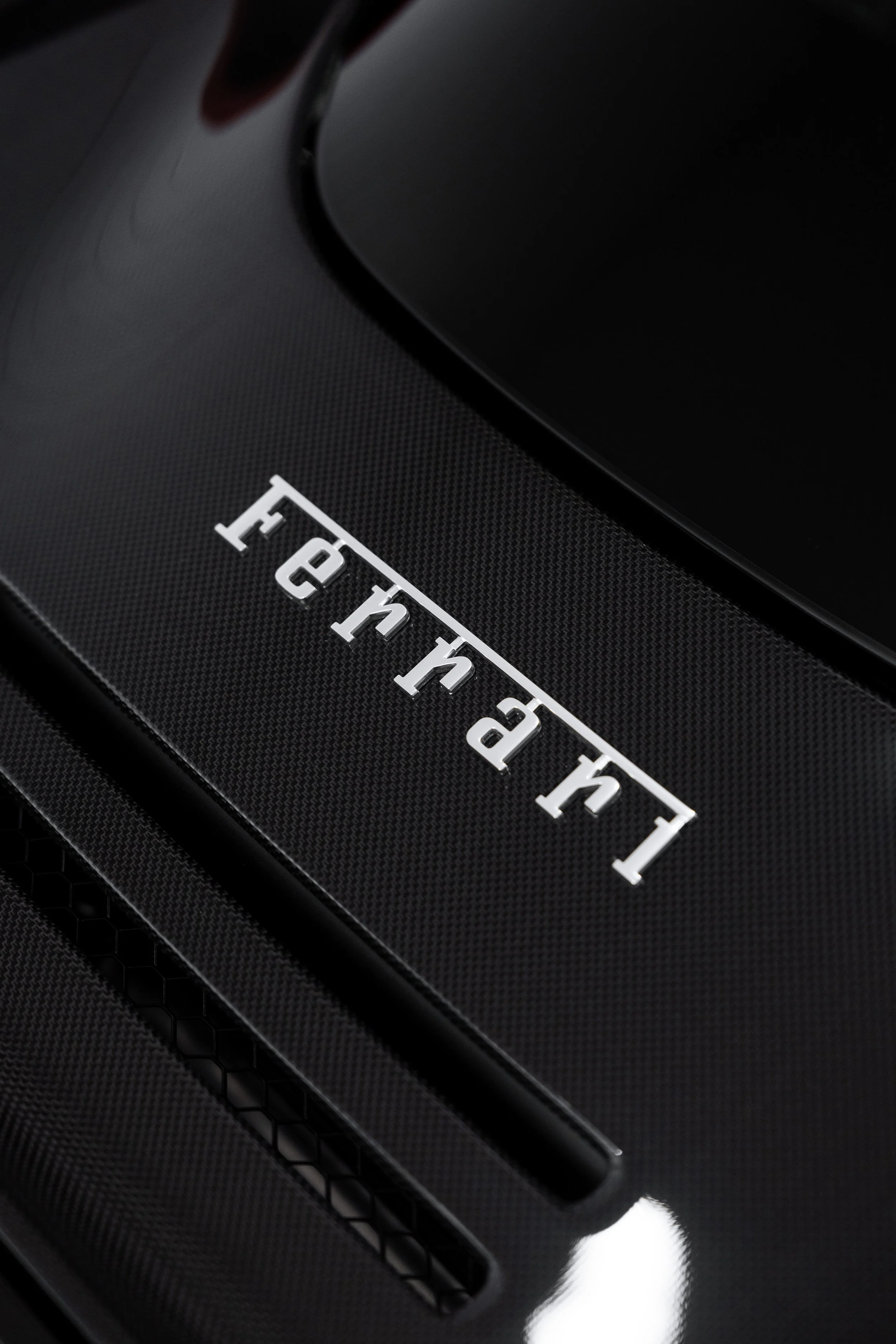 Ferrari script badge on carbon fibre engine cover with XPEL Paint Protection Film in Mona Vale