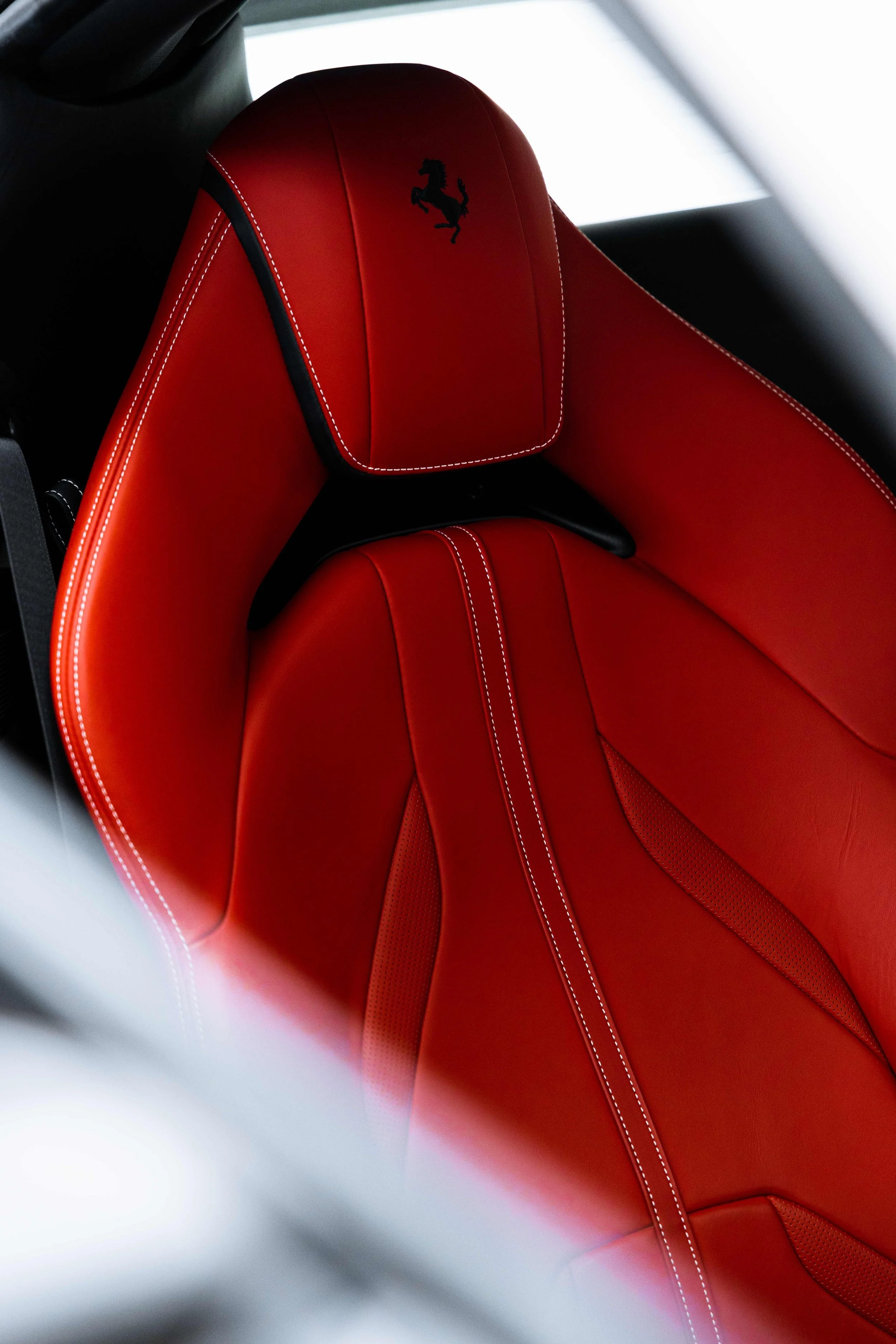 White Ferrari 812 GTS interior detailing red leather seat headrest with Ferrari shield in Sydney