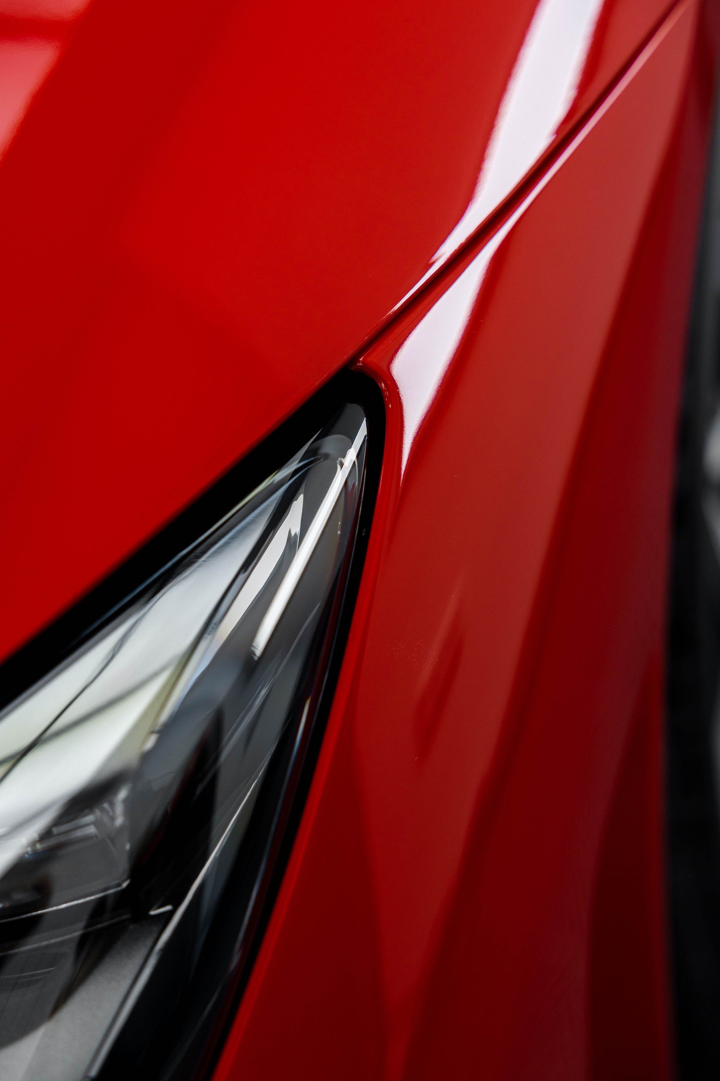 Red Ferrari 296 Speciale headlight and front guard close up with XPEL Paint Protection Film in Mona Vale