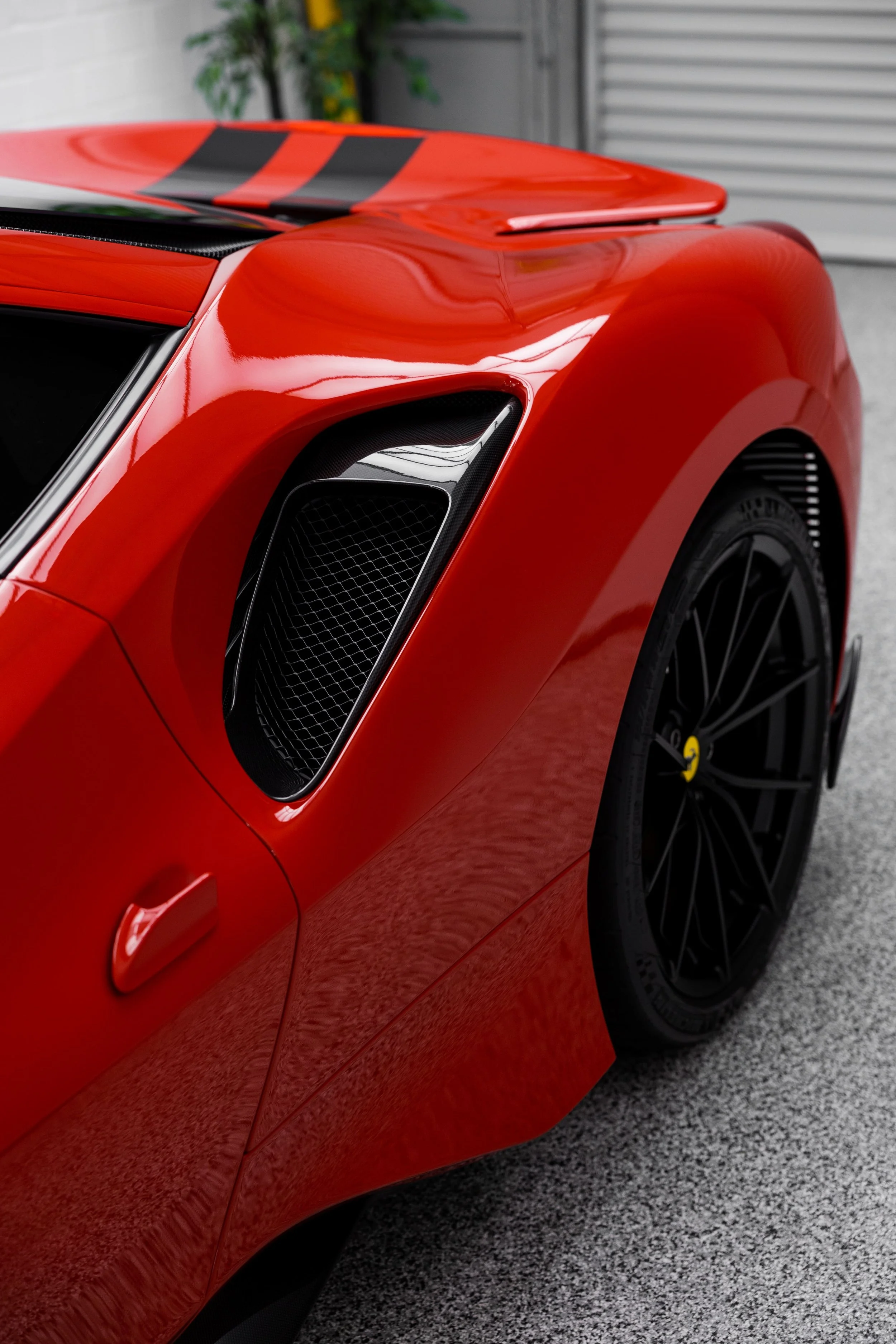 Ferrari 488 Pista rear quarter detail showing sculpted air intake, carbon fibre accents, and gloss red paint finish
