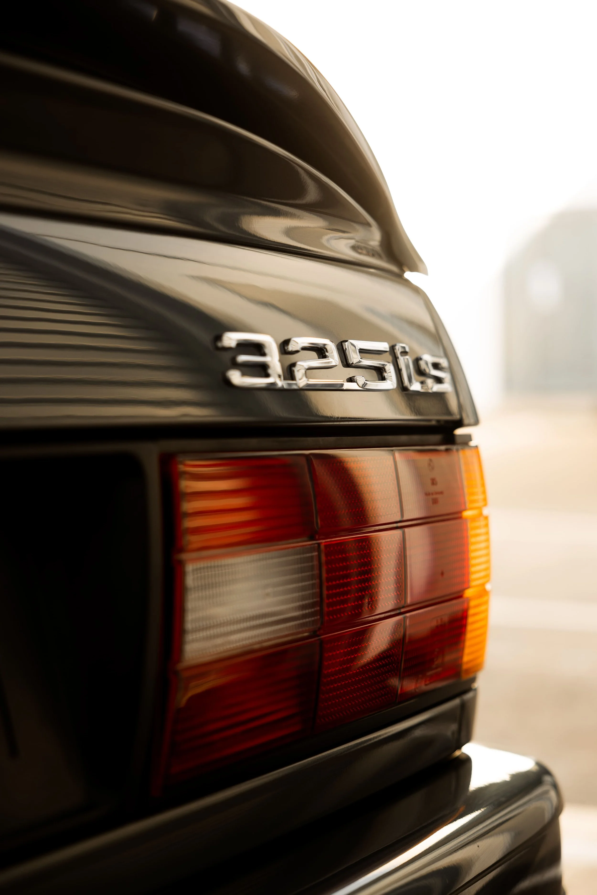 BMW E30 325is rear badge and taillight detail, highlighting classic model designation and vintage design preserved by Australian Detailing Services Sydney