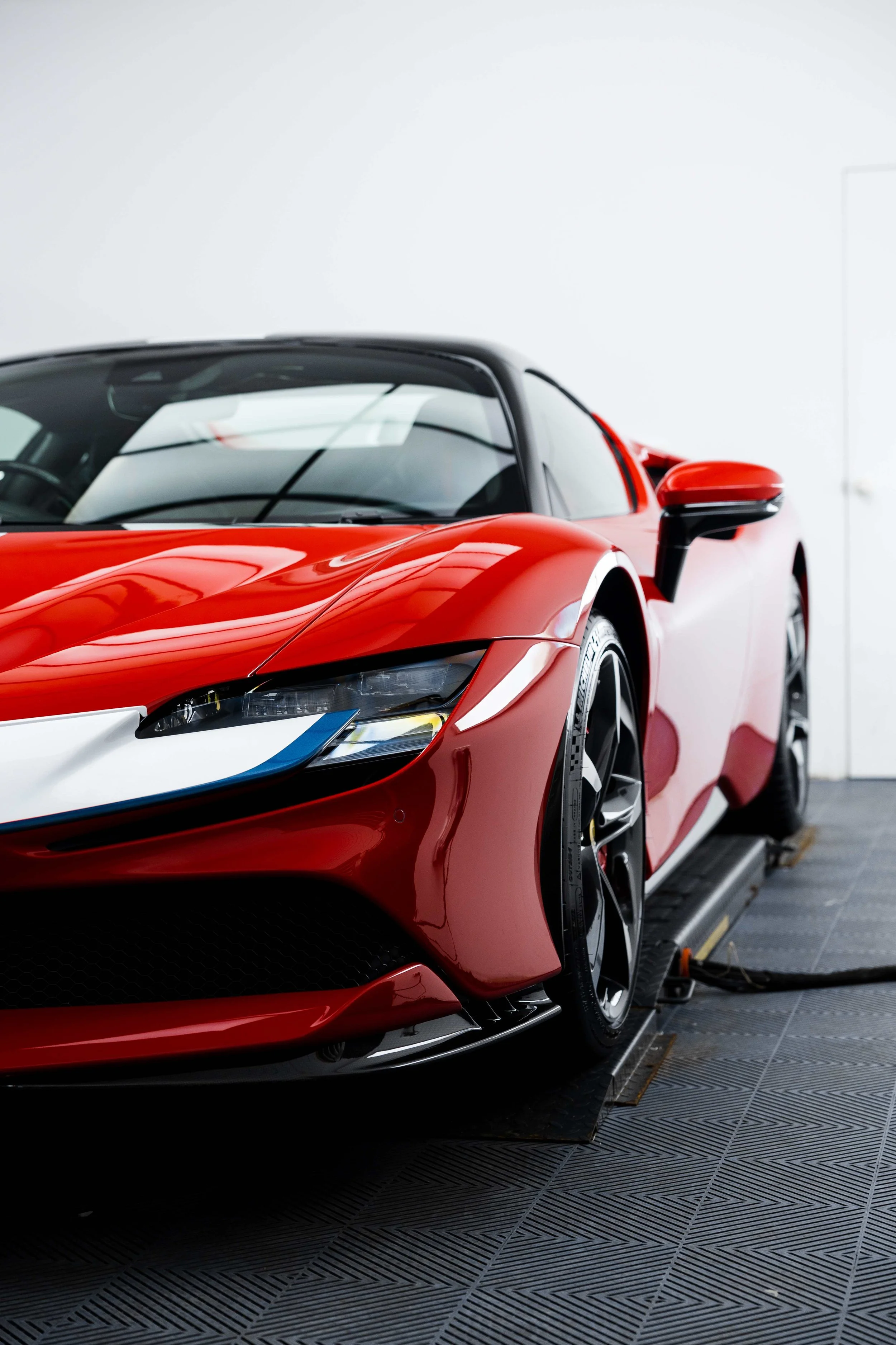 Red Ferrari SF90 Spyder front quarter, headlight and wheel with XPEL Paint Protection Film in Sydney