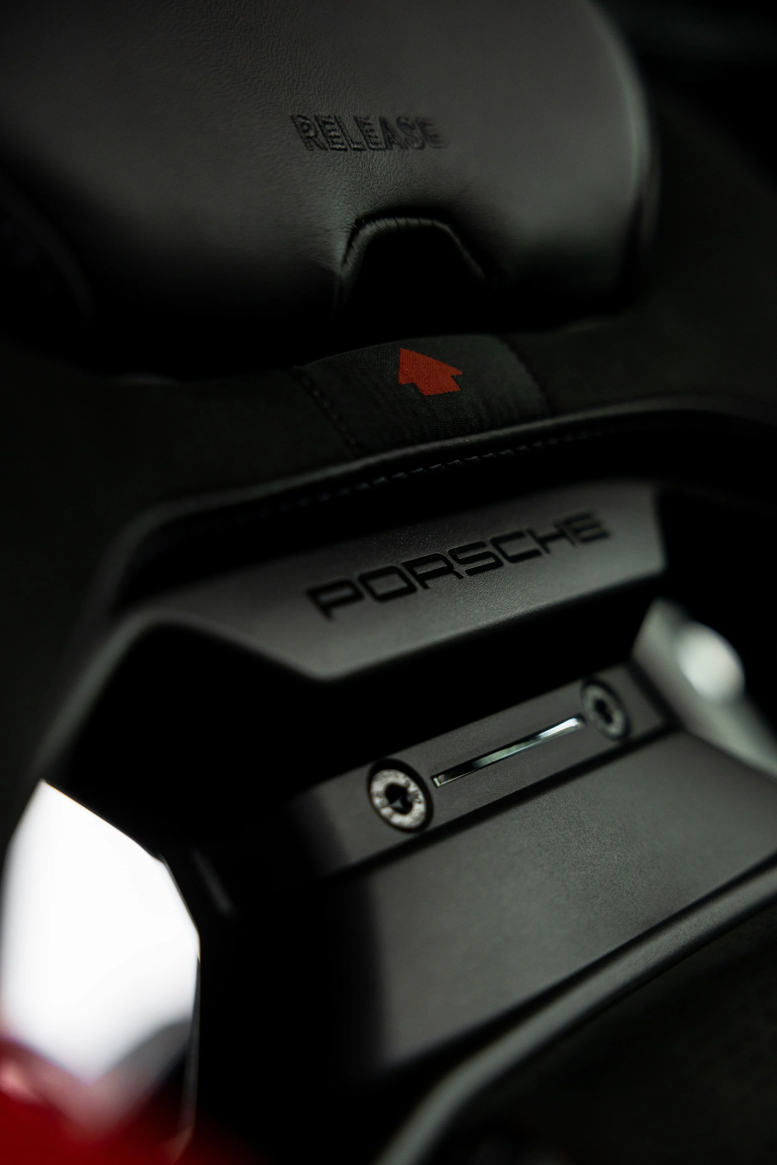 Close-up of Porsche 911 GT3 bucket seat release mechanism with Porsche branding and red detailing by ADS in Mona Vale