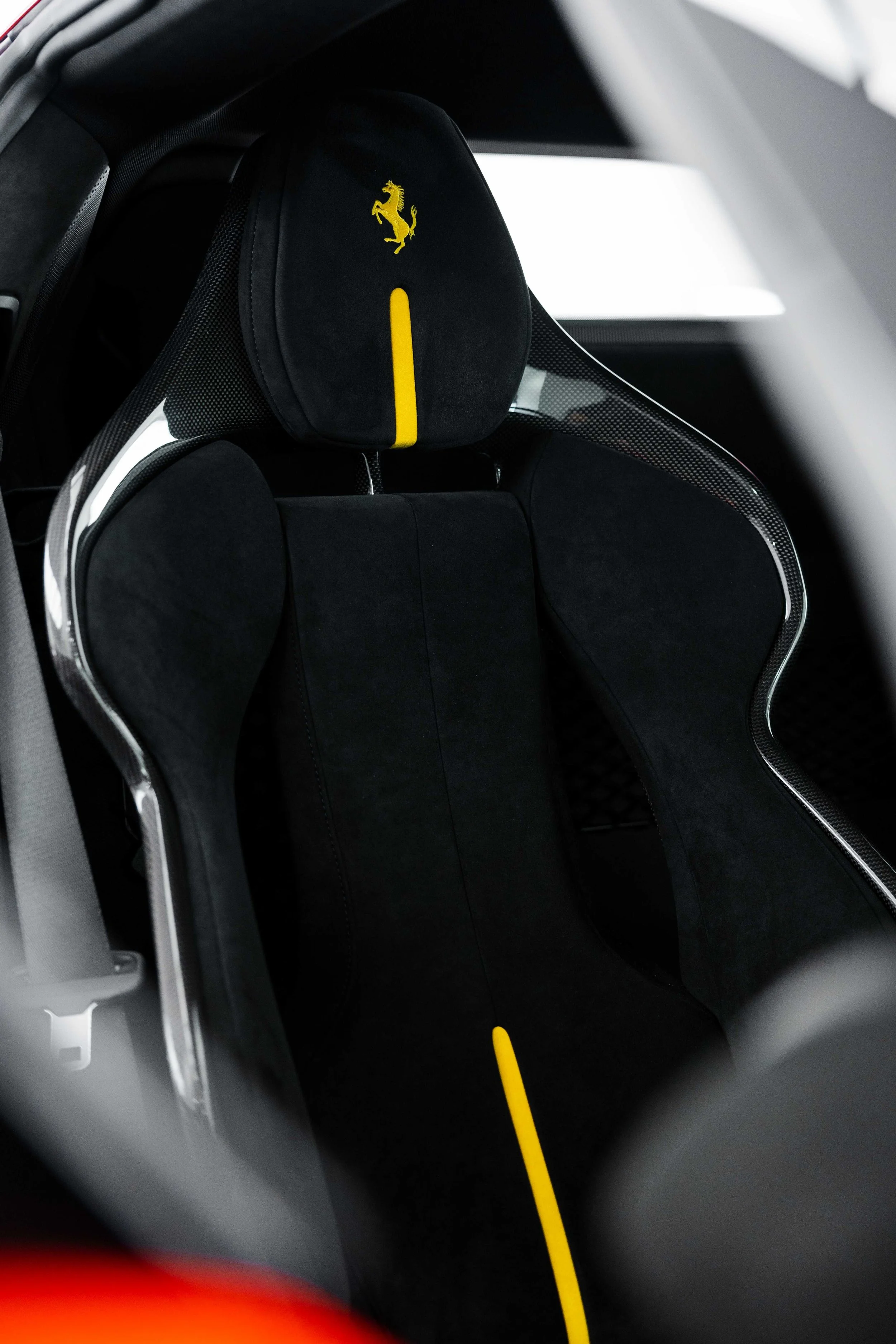 Red Ferrari 296 Speciale interior detailing carbon racing seat with yellow Prancing Horse headrest in Mona Vale