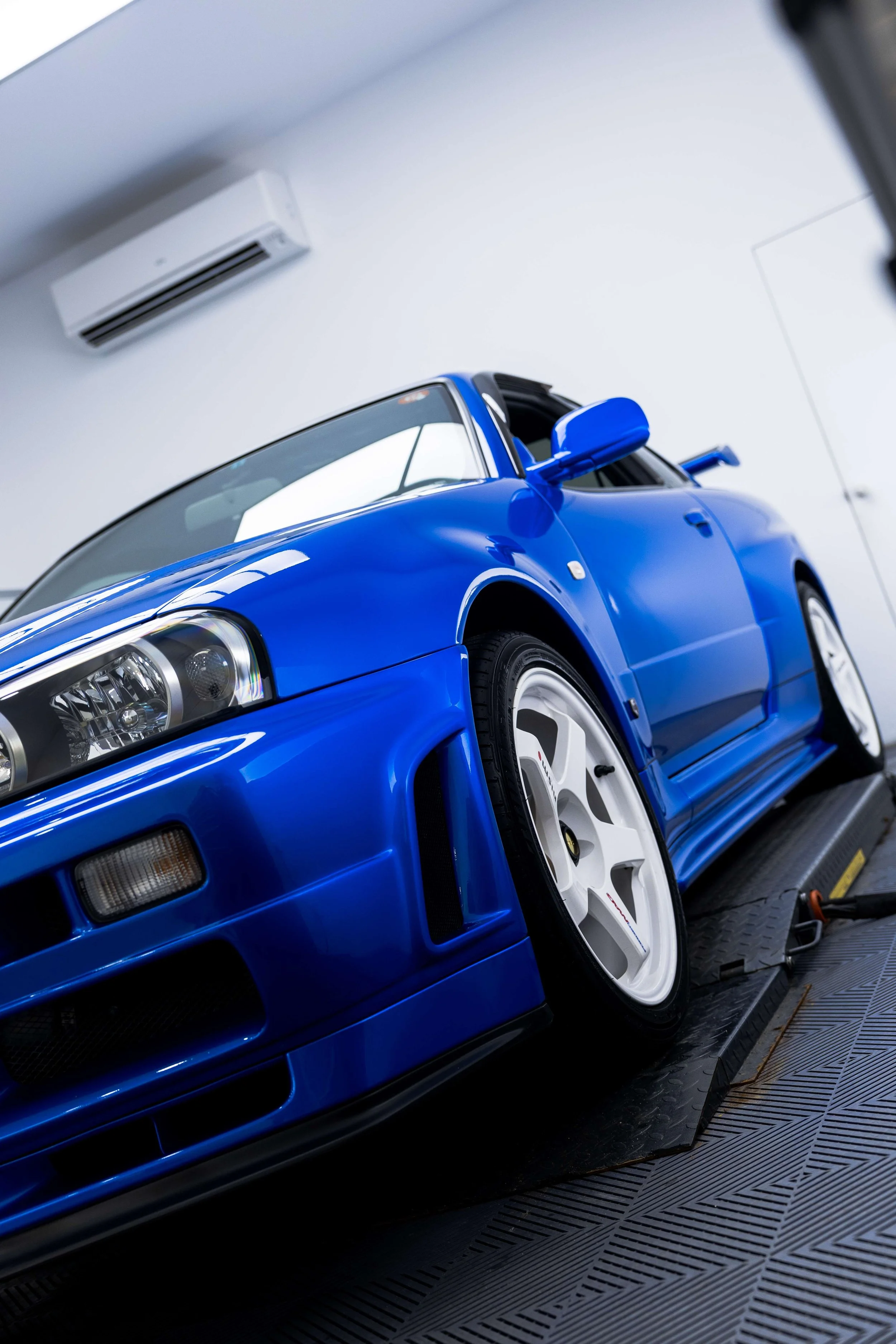 Bayside blue Nissan R34 GT-R Nur front three quarter view with XPEL Paint Protection Film in Mona Vale