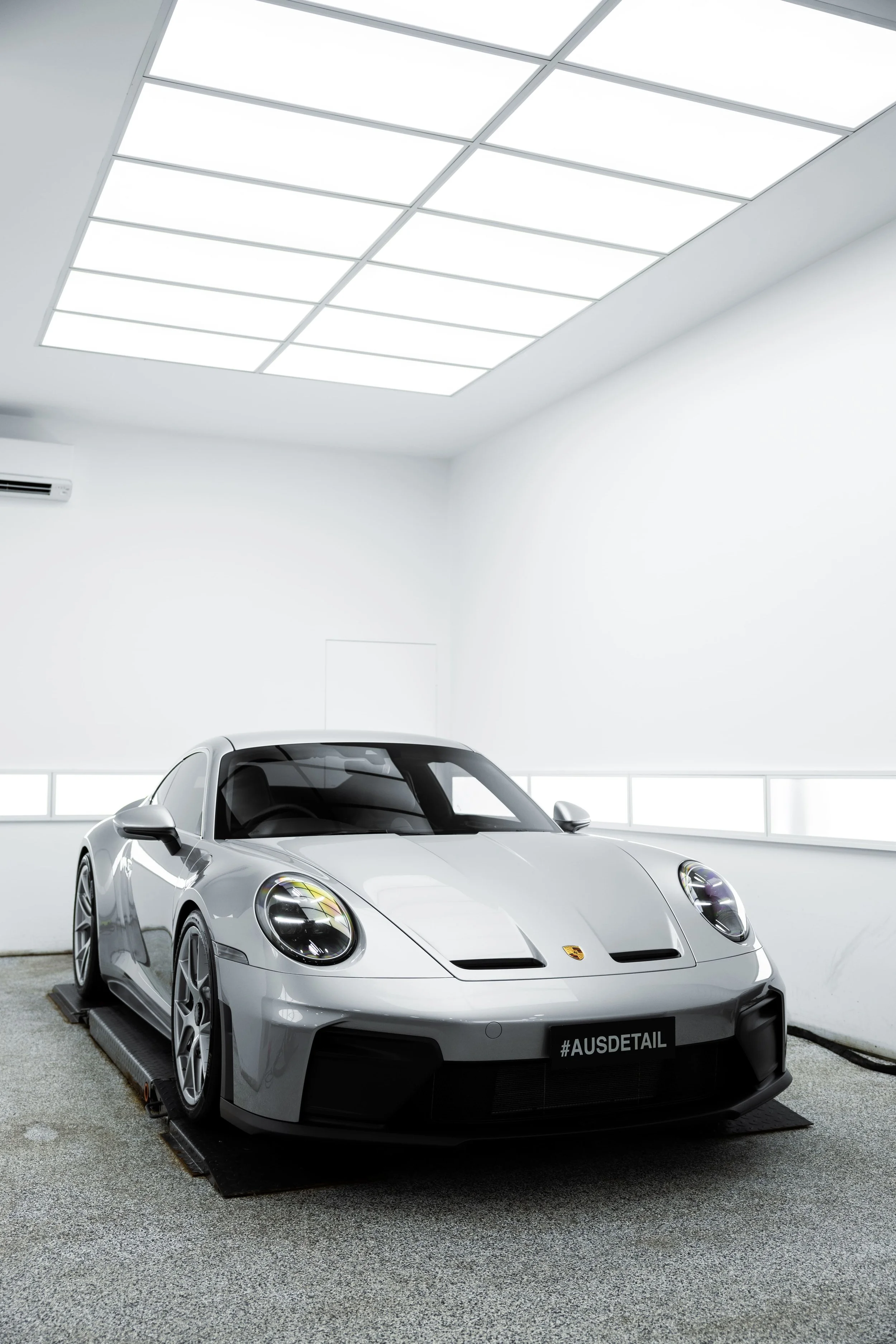 Silver Porsche 911 GT3 Touring front three-quarter view inside detailing studio, showcasing clean lines and high-gloss finish protected by Australian Detailing Services Sydney