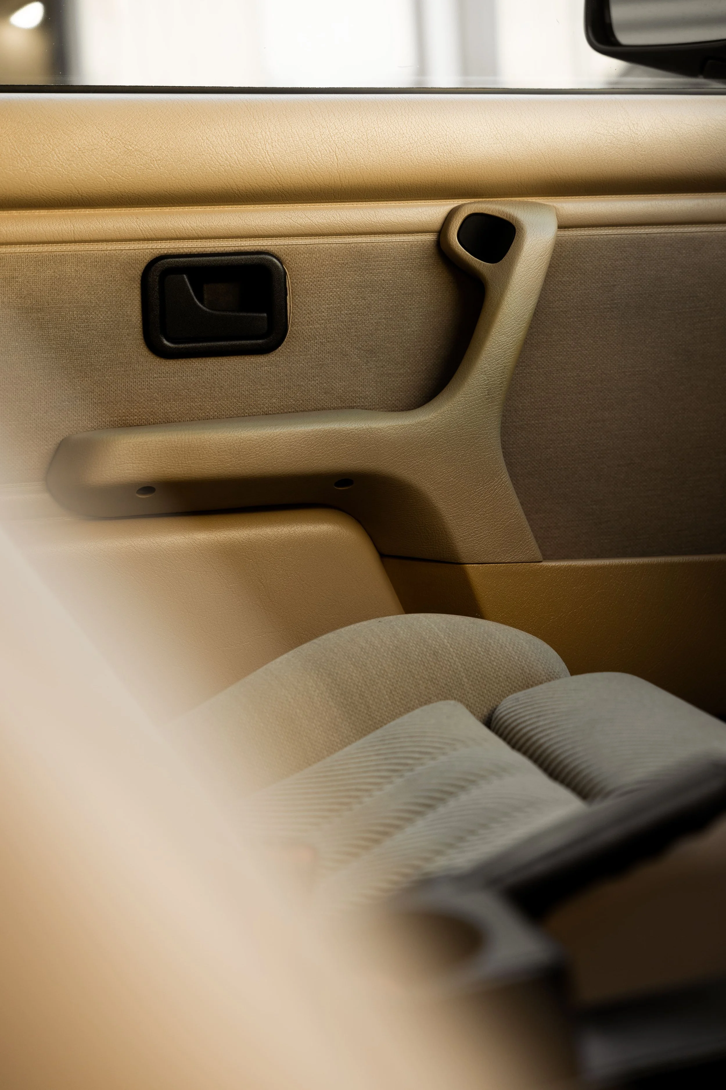 BMW E30 interior door panel in tan trim, highlighting classic analog design and original materials restored and preserved by Australian Detailing Services Sydney